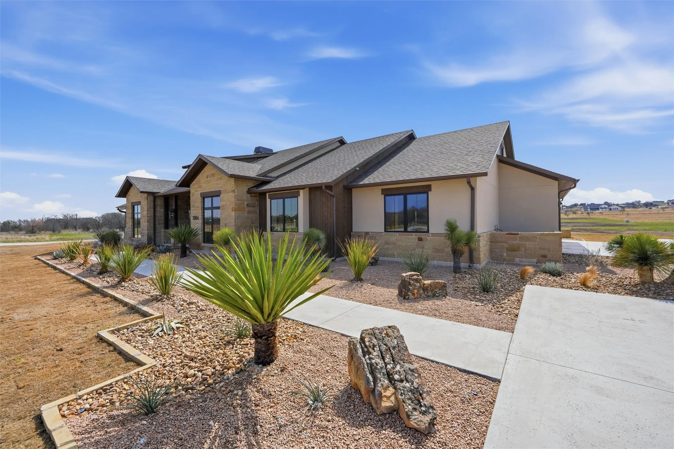 View of front of house featuring stone siding and stucco siding