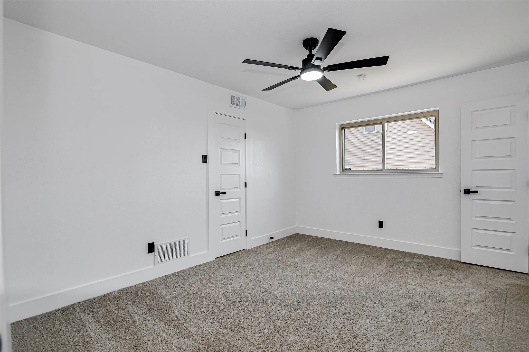 Bedroom room featuring light colored carpet and ceiling fan