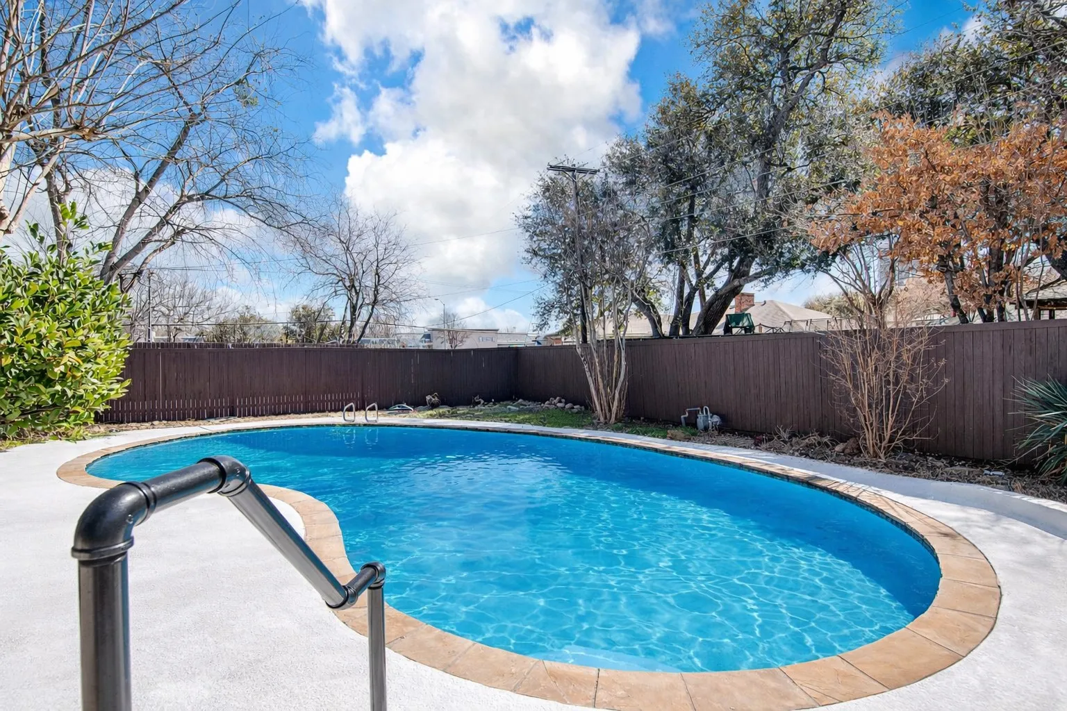 View of pool with a fenced backyard and patio surround
