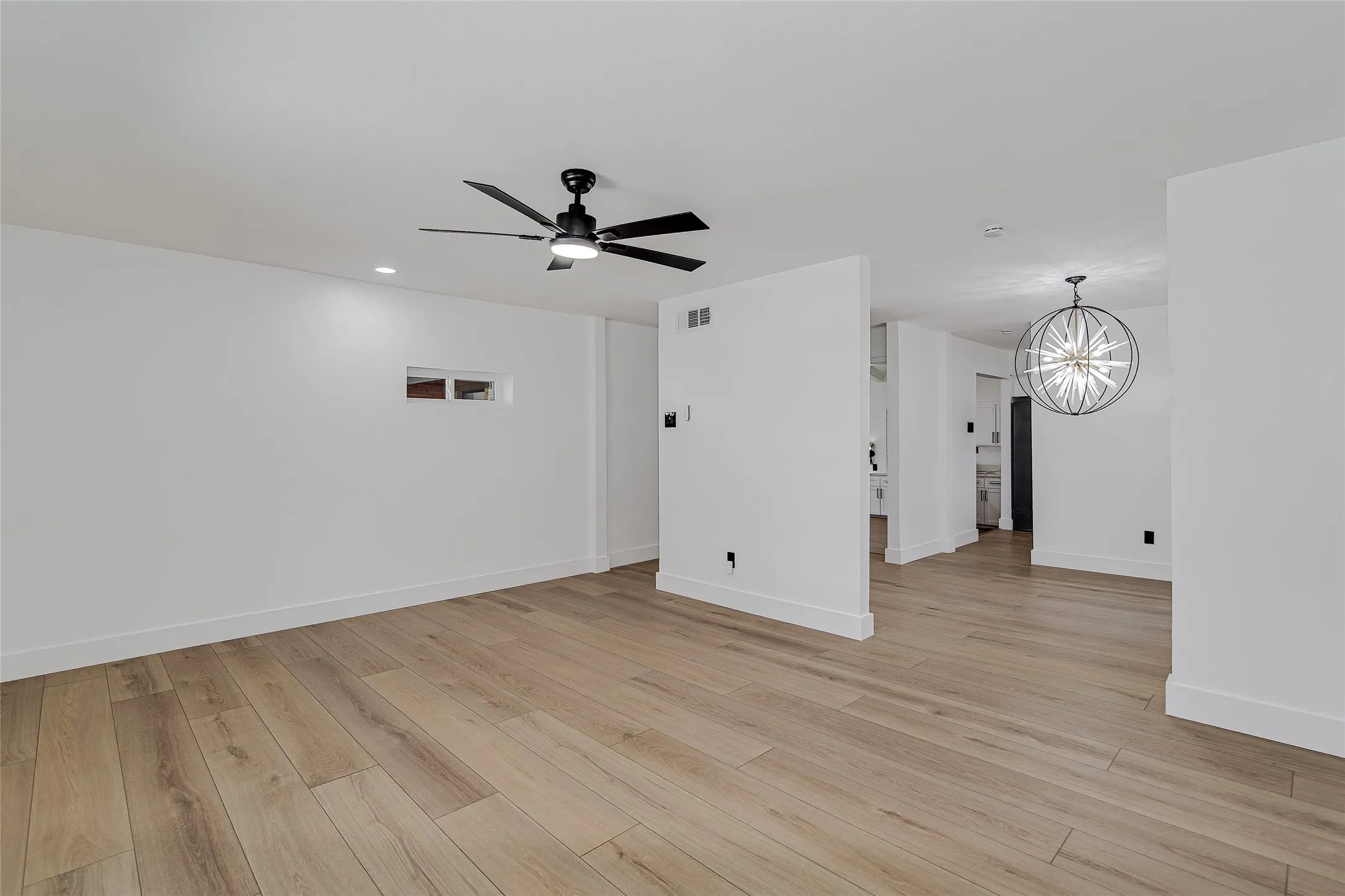 2nd living room with a ceiling fan and light wood-style floors. Flows into the dining room