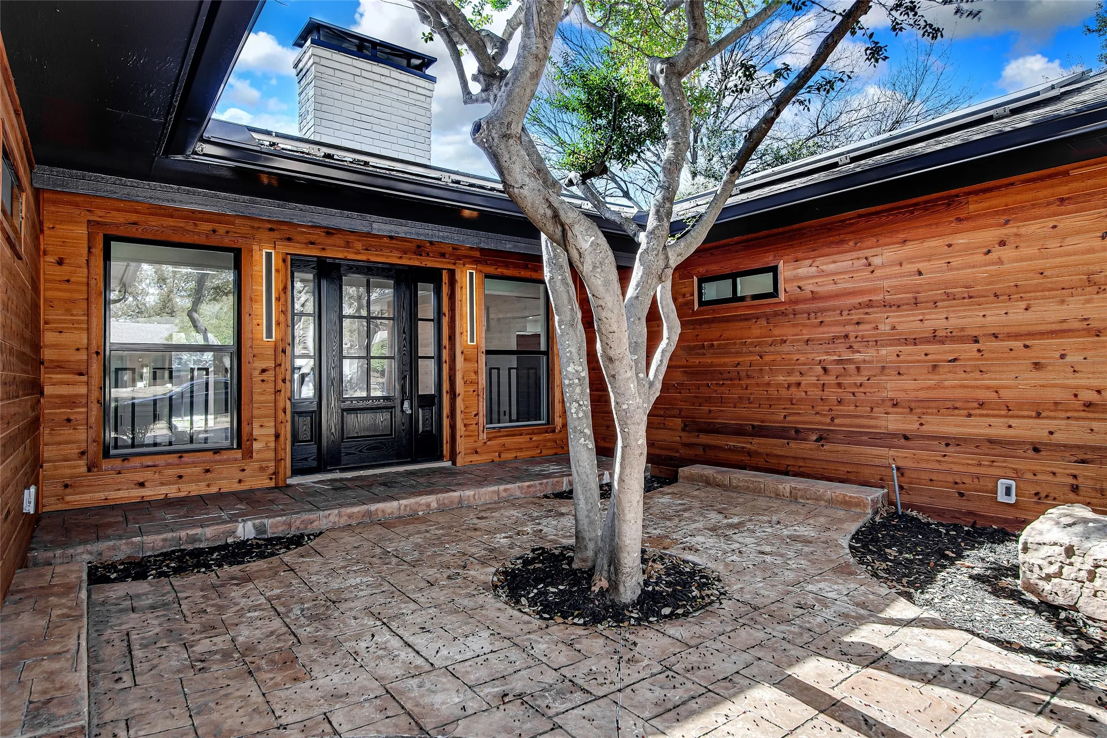 Entrance to property featuring a patio area and a chimney