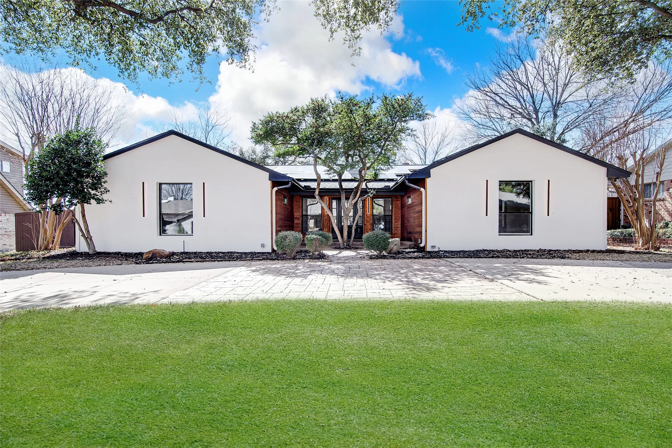 View of front of house with a front lawn and stucco siding