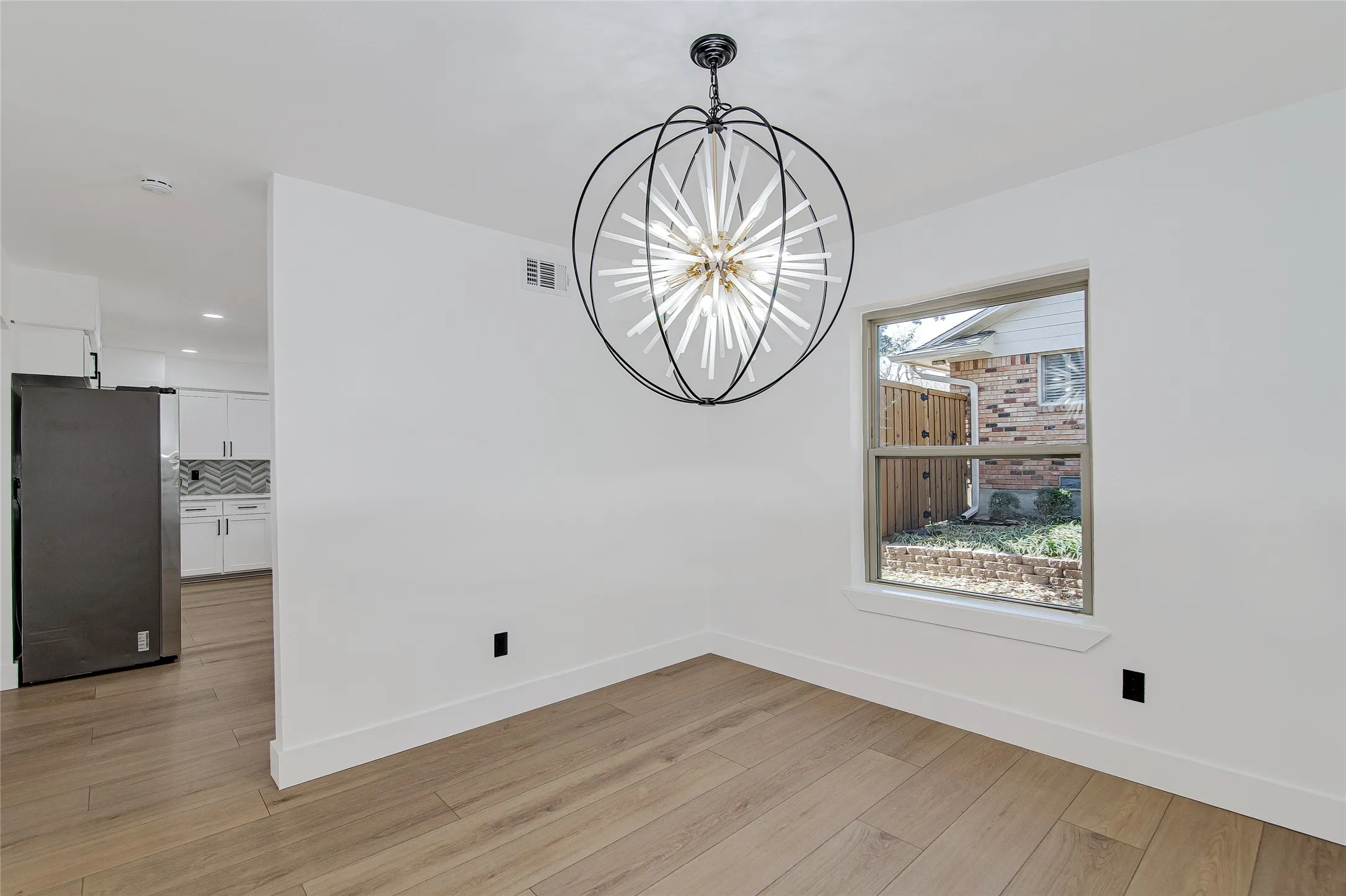 Unfurnished dining area with hanging lights and light wood-type flooring
