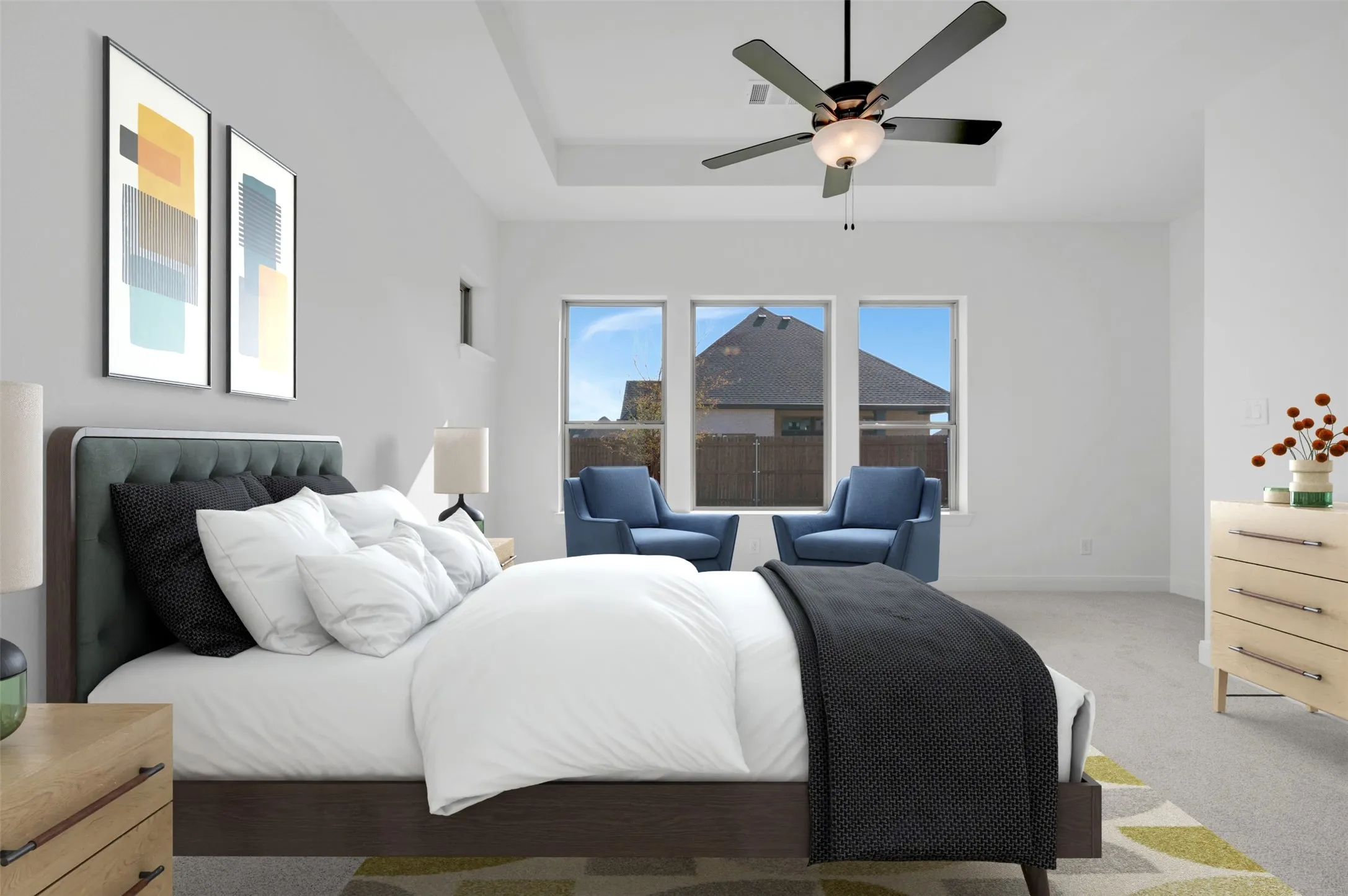 Spacious room featuring a tray ceiling, ceiling fan with integrated lighting, and three large windows