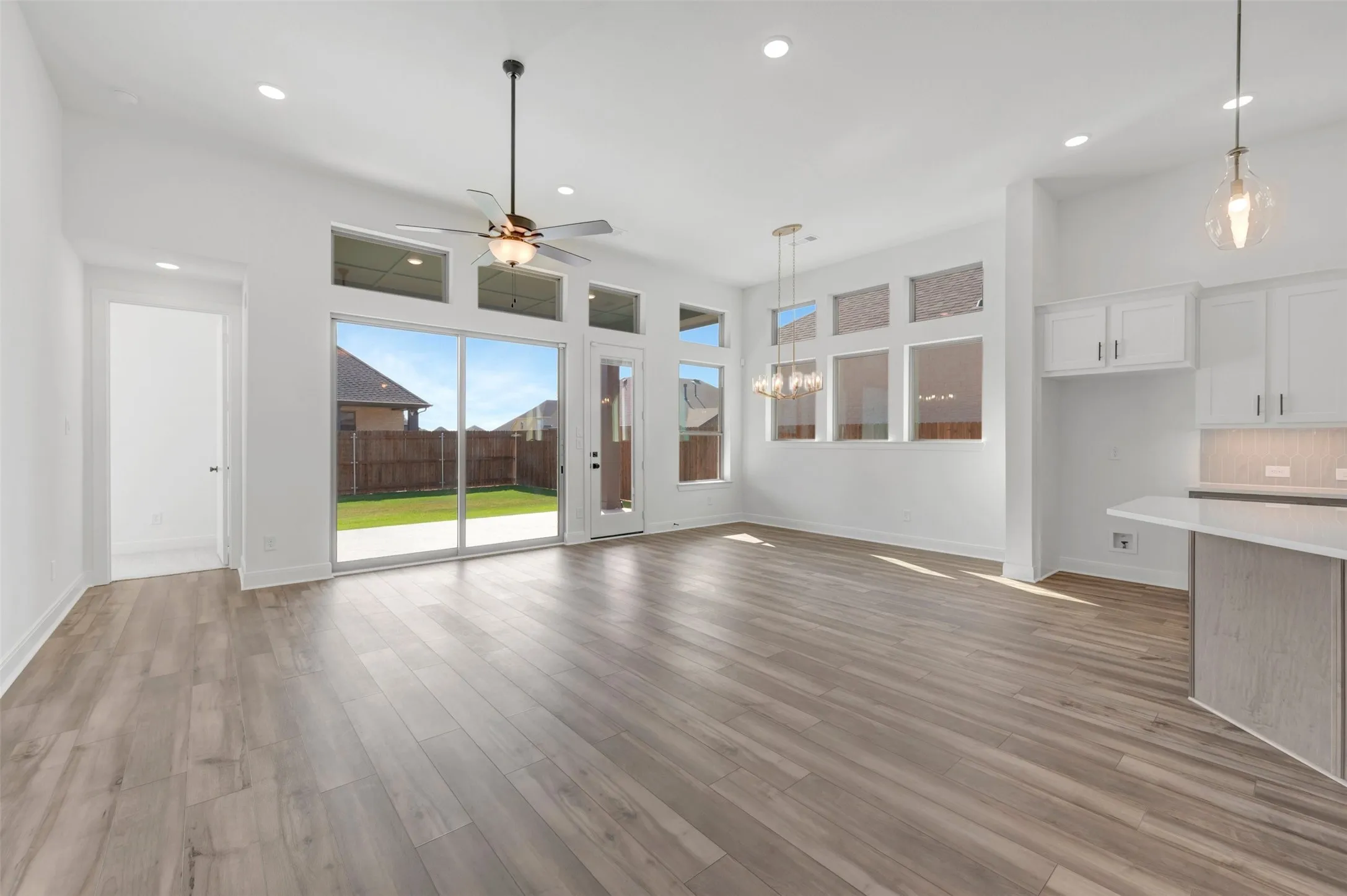 Spacious living area featuring wood-finish flooring, recessed lighting, and a ceiling fan