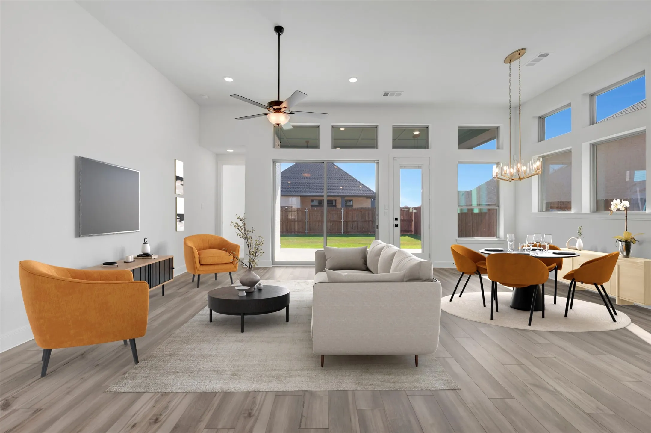 Open-concept living space featuring wood-finish flooring, high ceilings, and recessed lighting