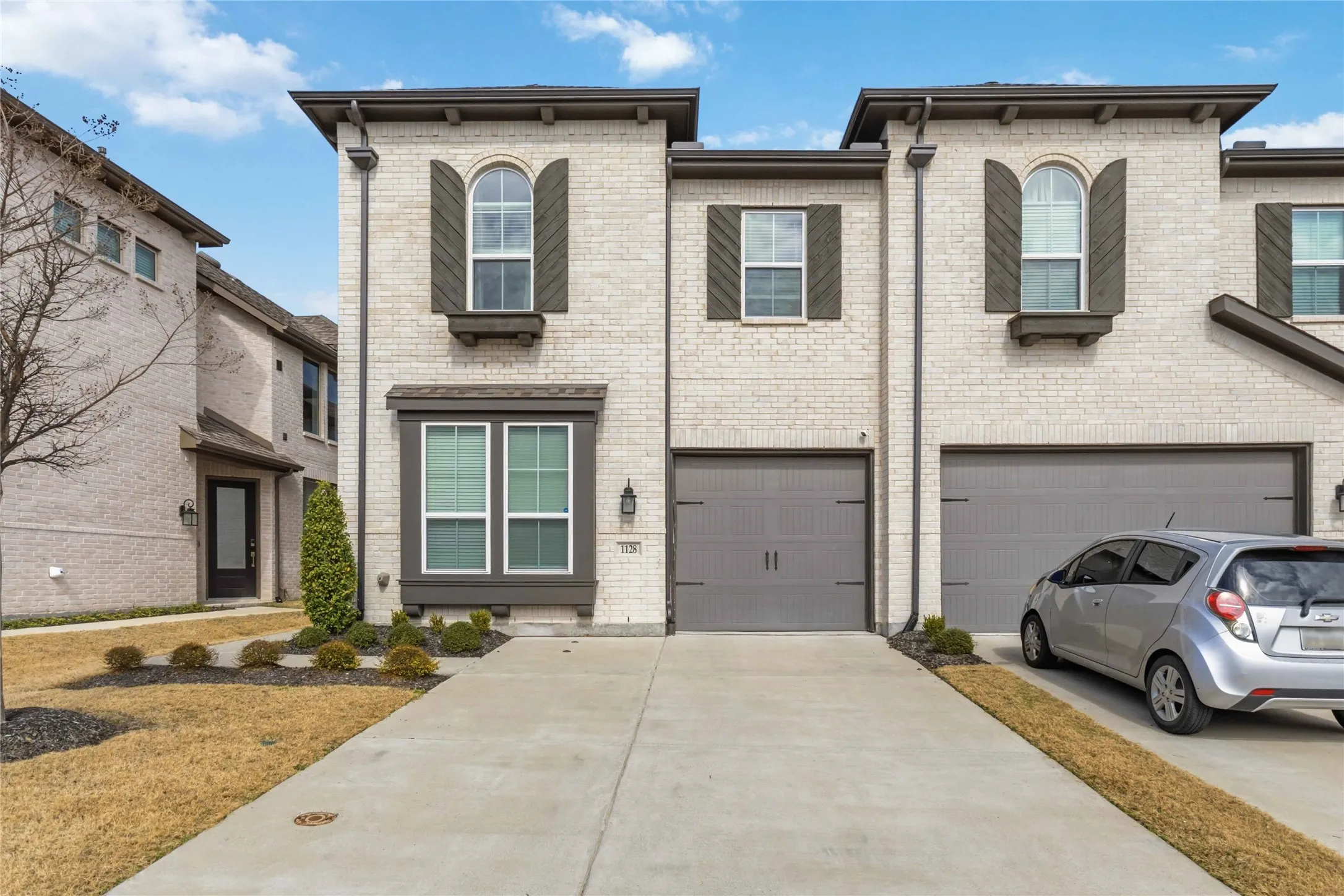 View of front of home featuring brick siding, an attached garage, and concrete driveway