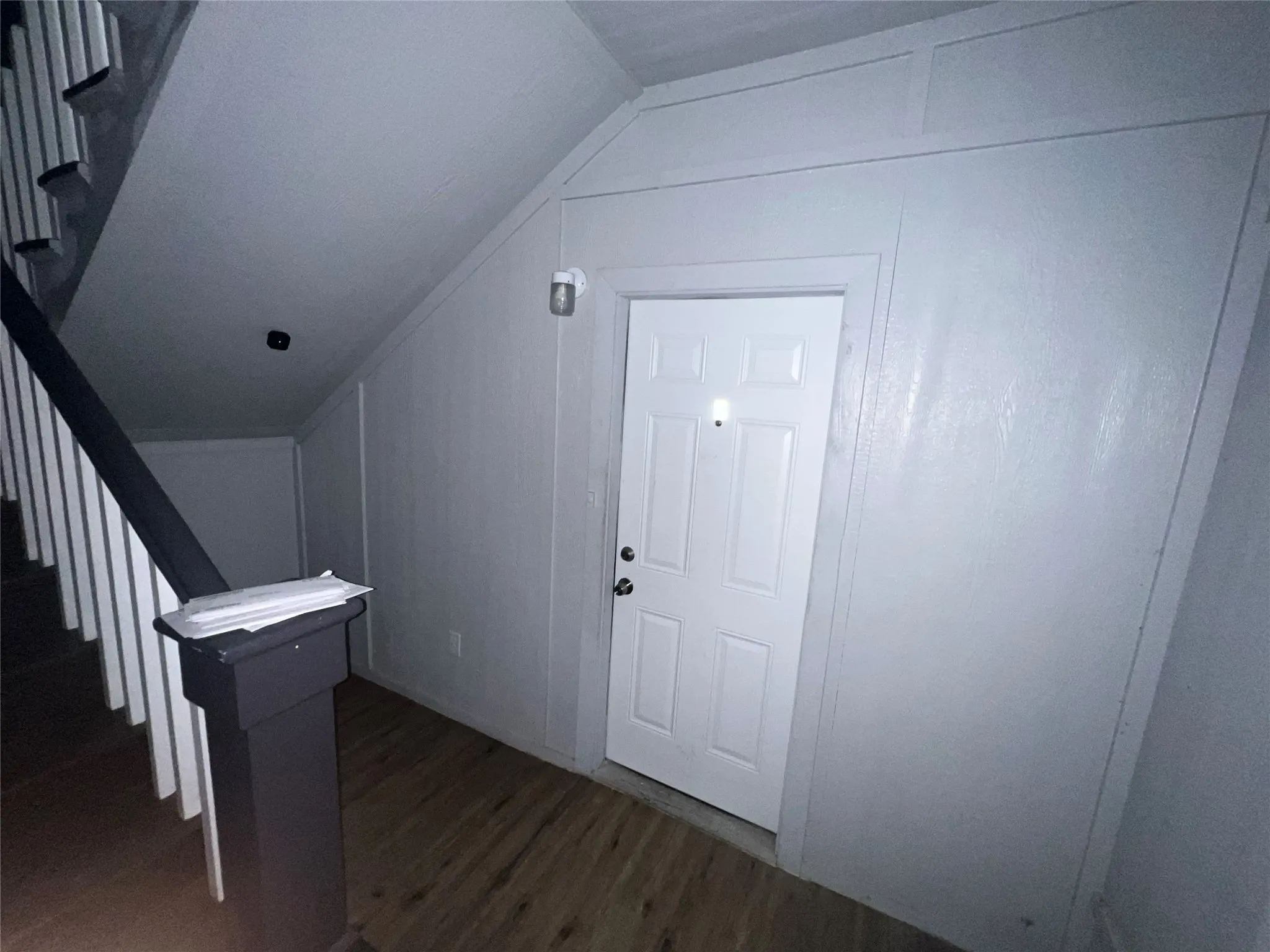Foyer with dark wood finished floors and lofted ceiling