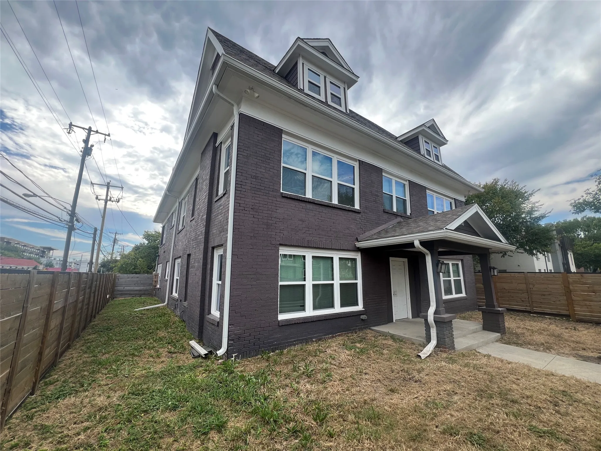 American foursquare style home with a fenced backyard and brick siding
