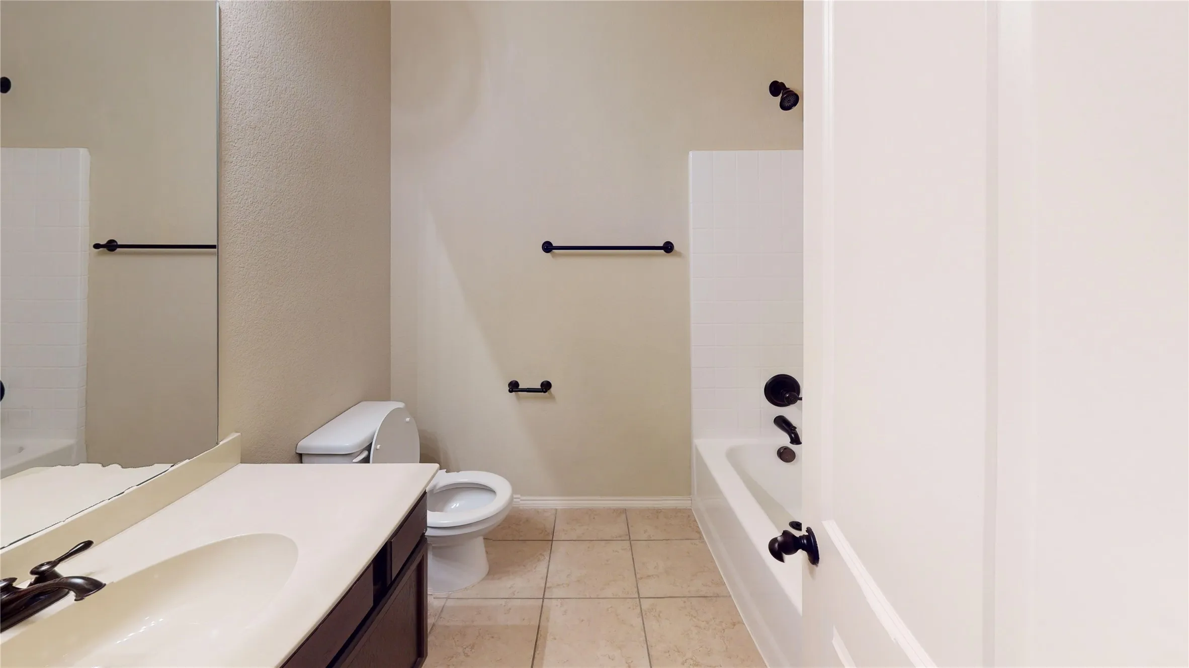 Bathroom with vanity, shower / bath combination, and light tile patterned flooring