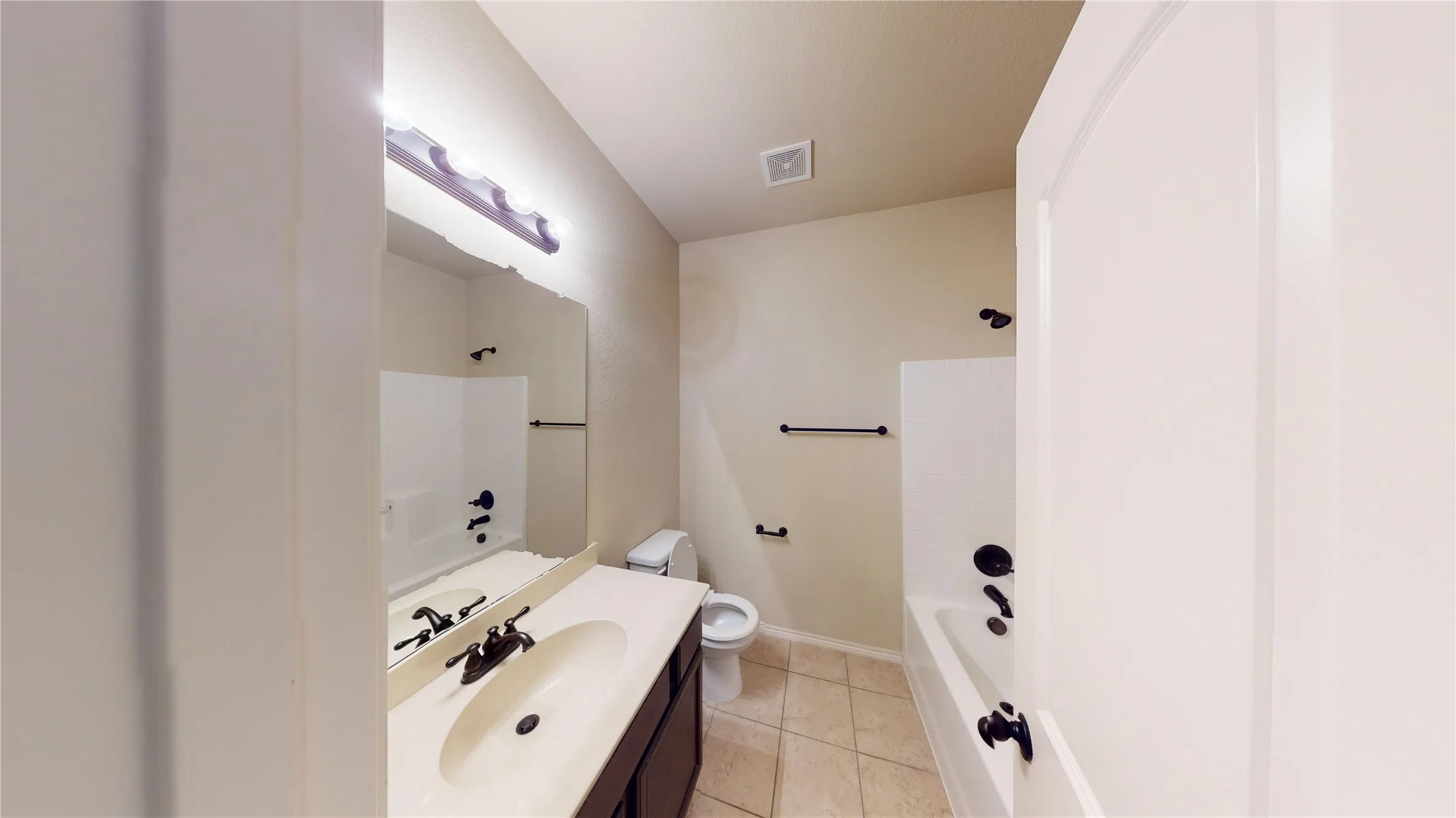 Full bathroom with vanity, light tile patterned floors, and shower / tub combination