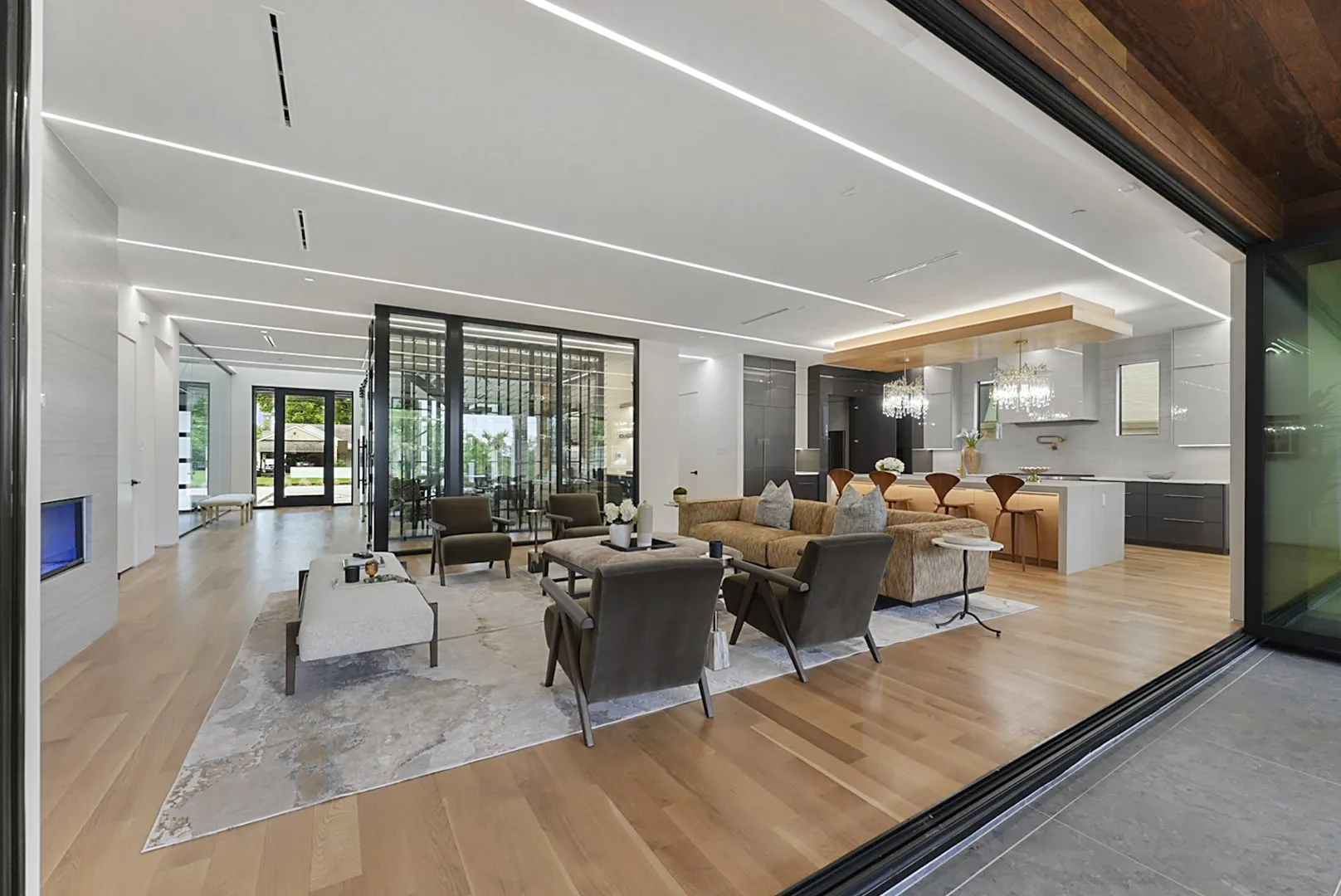 The heart of the home: linear fireplace, glass feature wall, and island kitchen in one seamless space