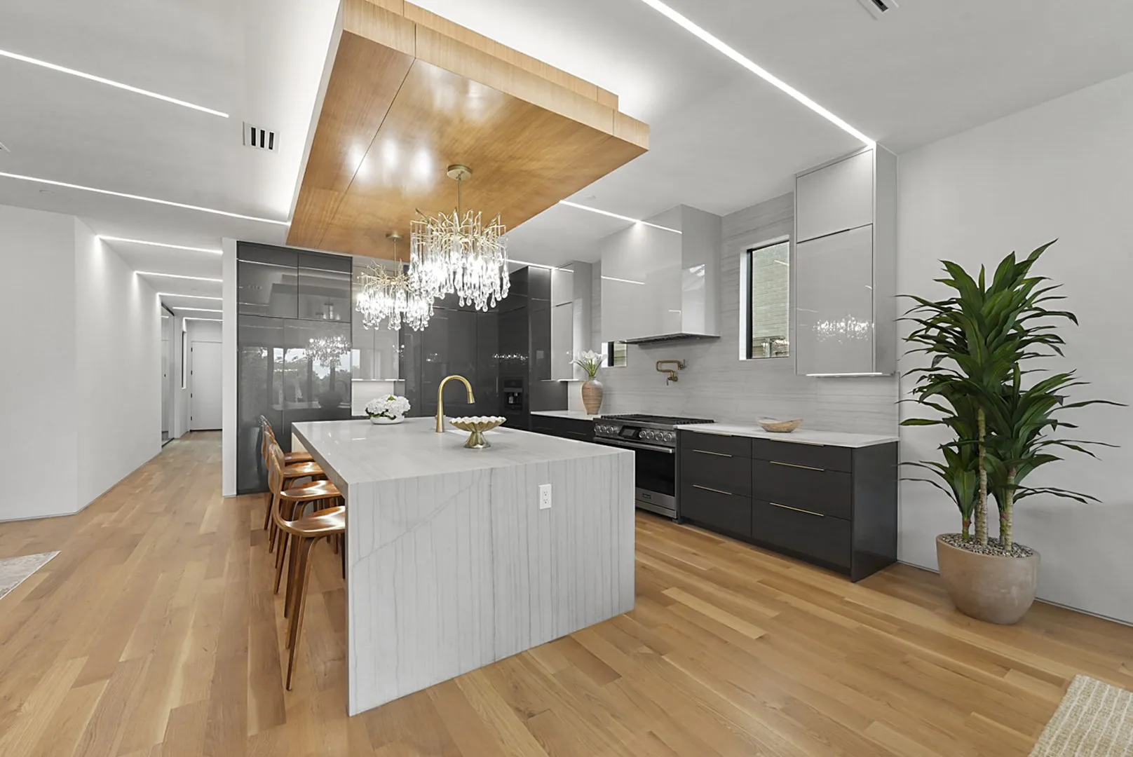 Gourmet kitchen: waterfall island seating under twin crystal chandeliers
