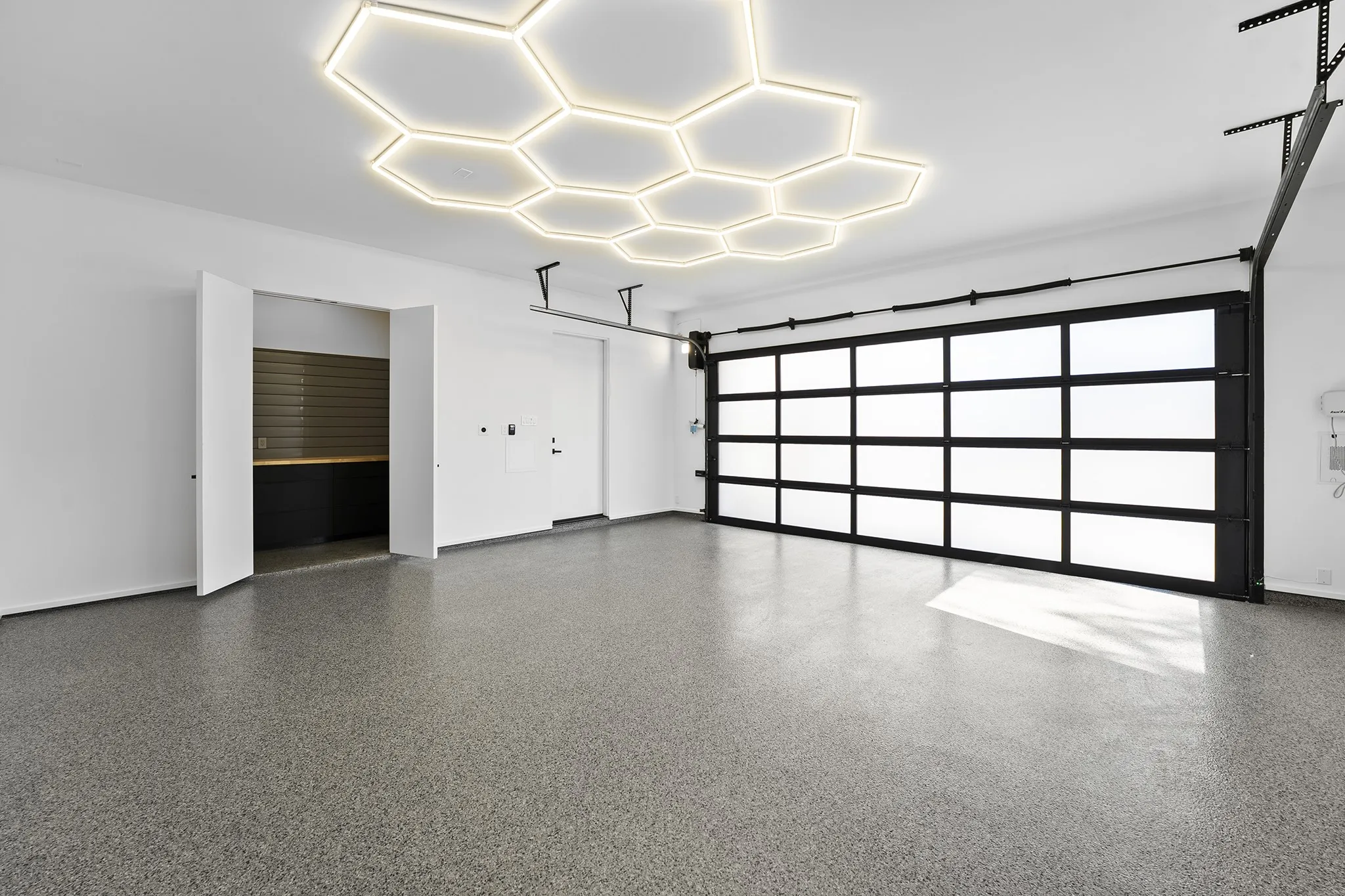 Oversized garage with designer hex lighting and glass roll-up door