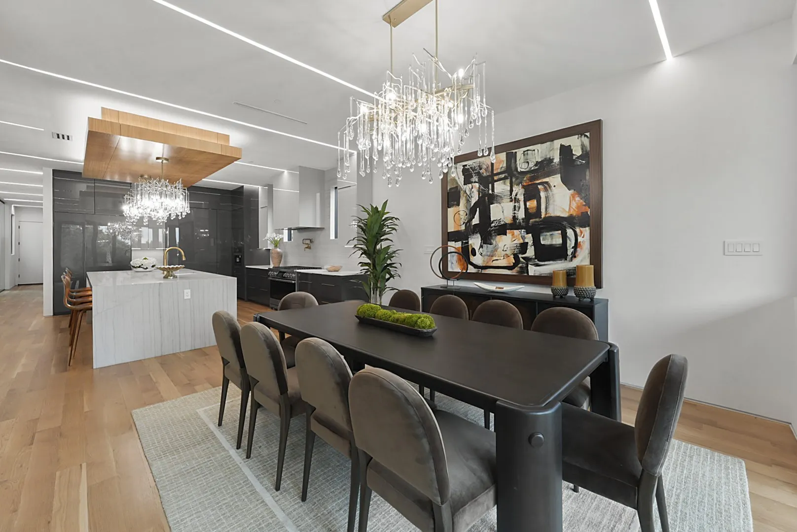 Crystal chandelier and linear lighting elevate the open living-dining flow