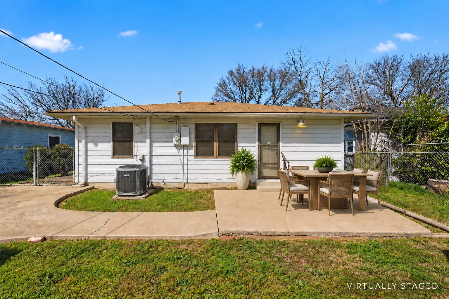 White horizontal siding, asphalt shingle roof, concrete patio, concrete pathways, and chain link fencing