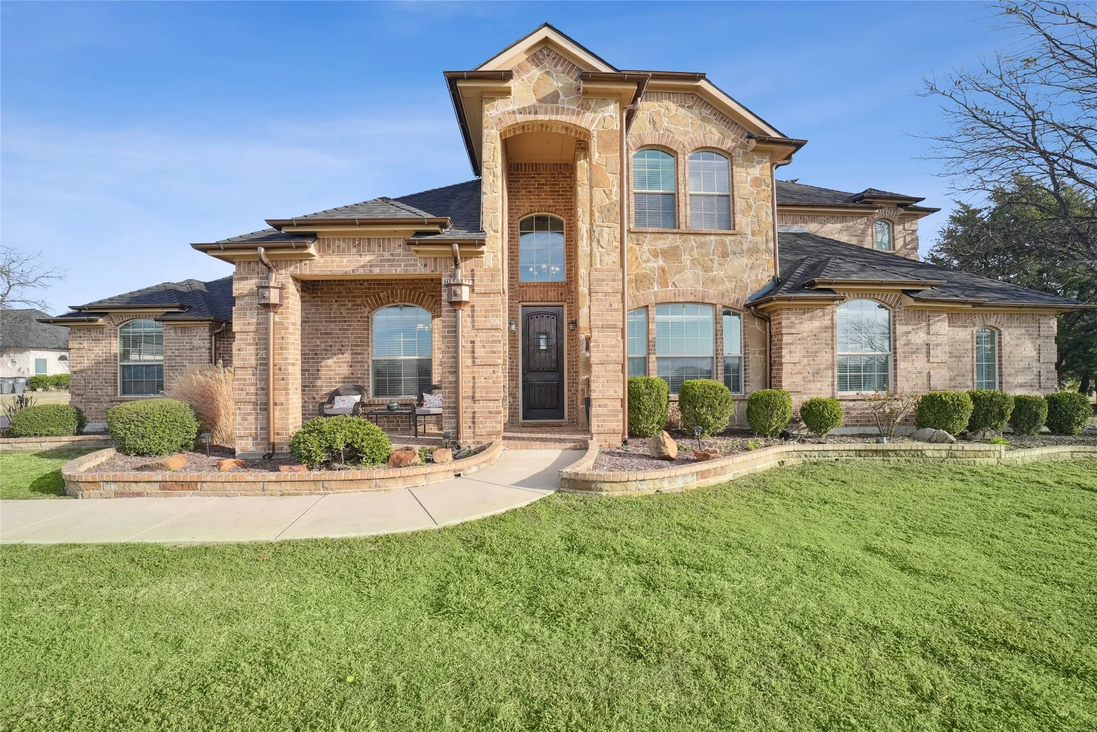Custom gutters and expansive front lawn with potential for a circular driveway.