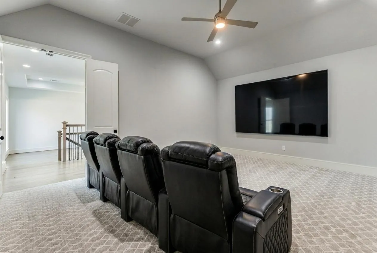 Cinema room featuring patterned carpet, ceiling fan, recessed lighting, and lofted ceiling.  VIRTUALLY STAGED