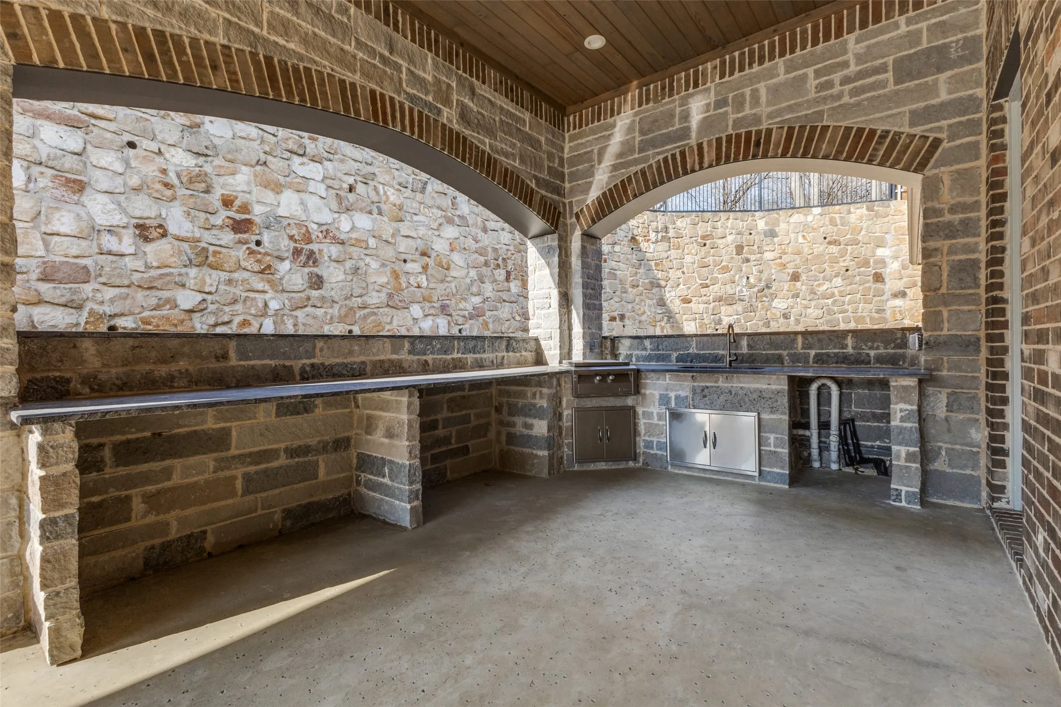 Large covered patio ready to be customized by new owner with grill, griddle, refrigerator, green egg, or anything desired!
