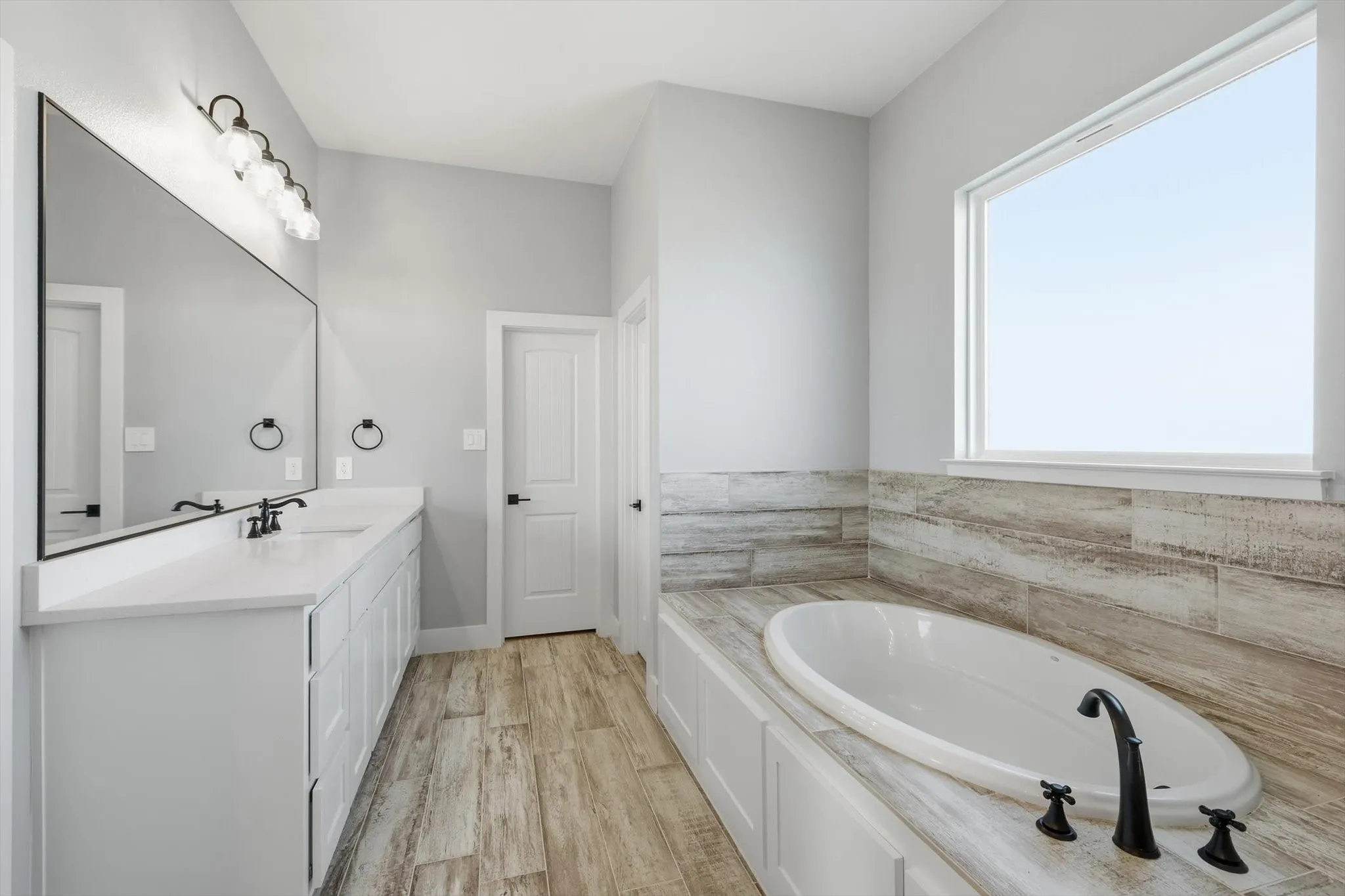 Soak and unwind. Oversized tub framed by warm tile surround—your end-of-day reset spot.