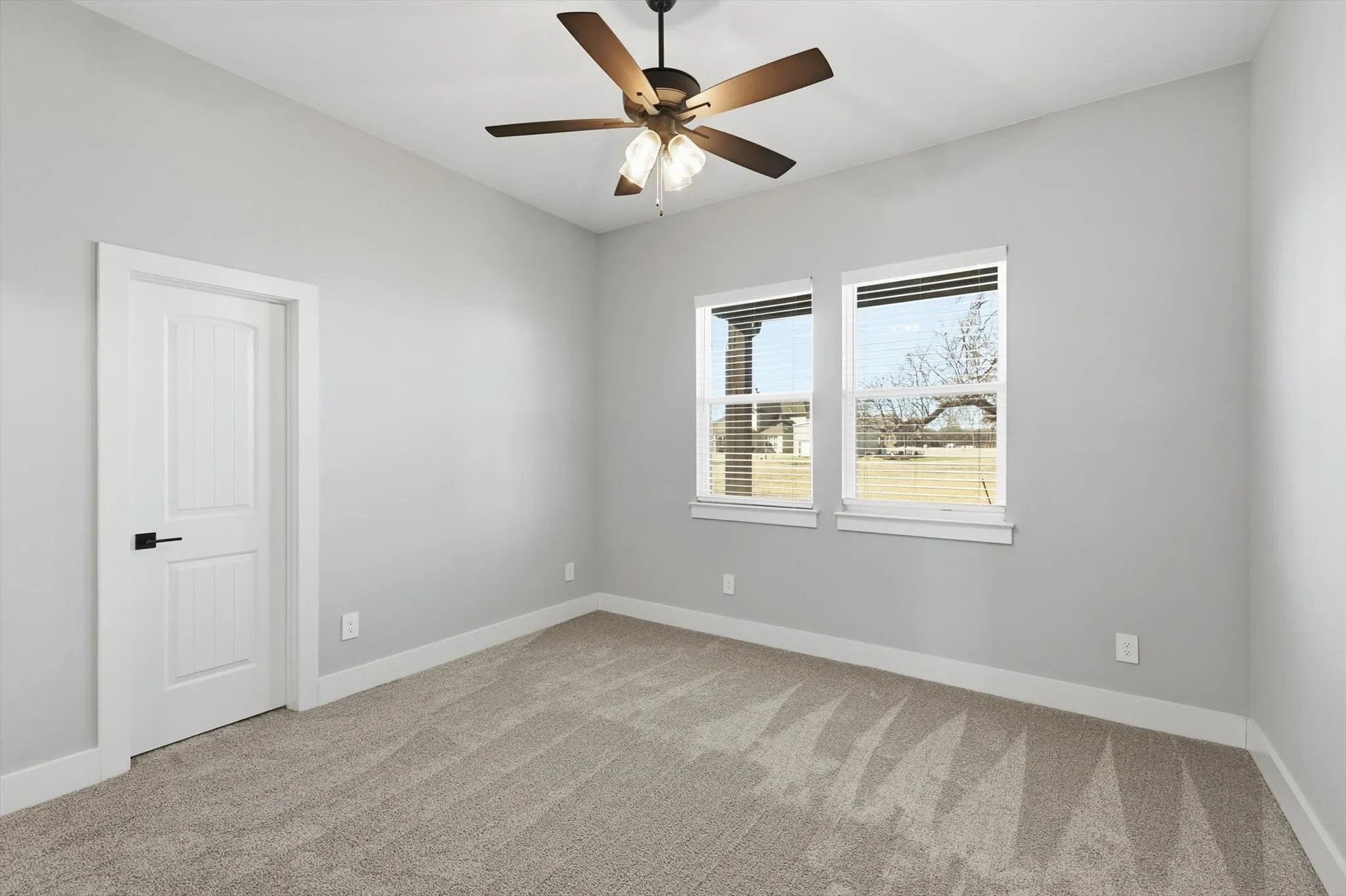Bright secondary bedroom. Soft carpet, modern ceiling fan, and great natural light—perfect for guests, kids, or a home office.