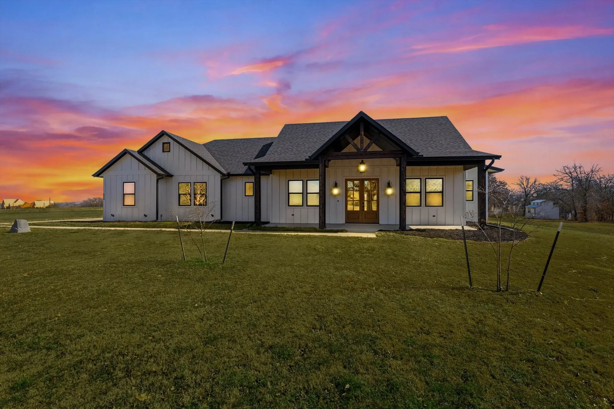 As the sun sets, this home truly shines—warm lighting, striking architectural details, and a colorful evening sky create an unforgettable first impression.