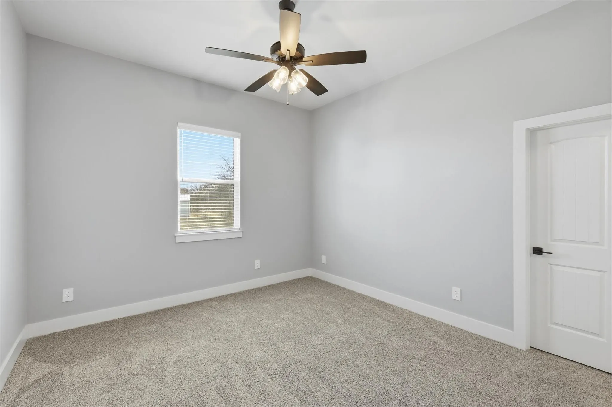 Another roomy bedroom option. Neutral tones, plush carpet, and a modern fan—ready for any setup from nursery to guest room.