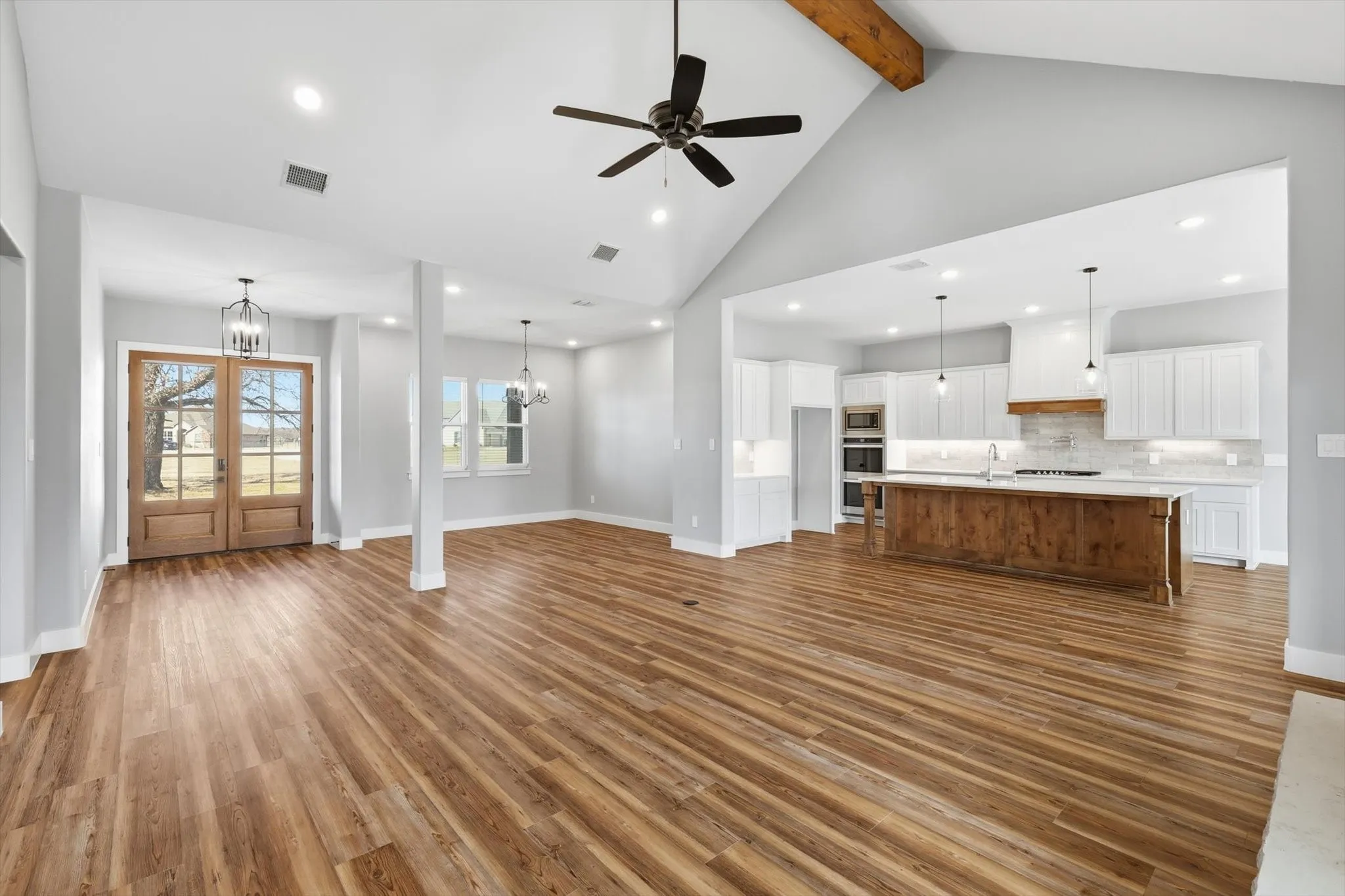 Stunning open layout showcasing the chef’s kitchen and oversized island, with dining and entry nearby—designed for gatherings and easy everyday living.