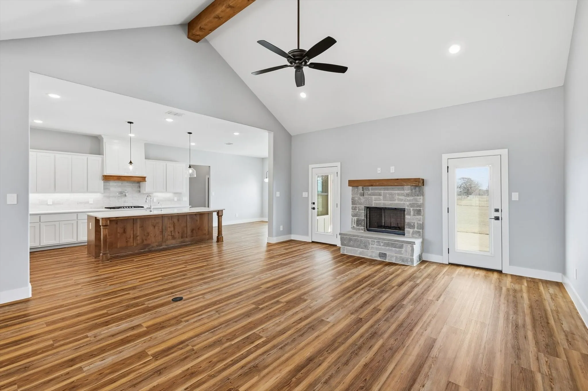 The heart of the home. A beautiful stone fireplace anchors the living room, with outdoor access on both sides—ideal for indoor/outdoor flow and relaxed weekends.