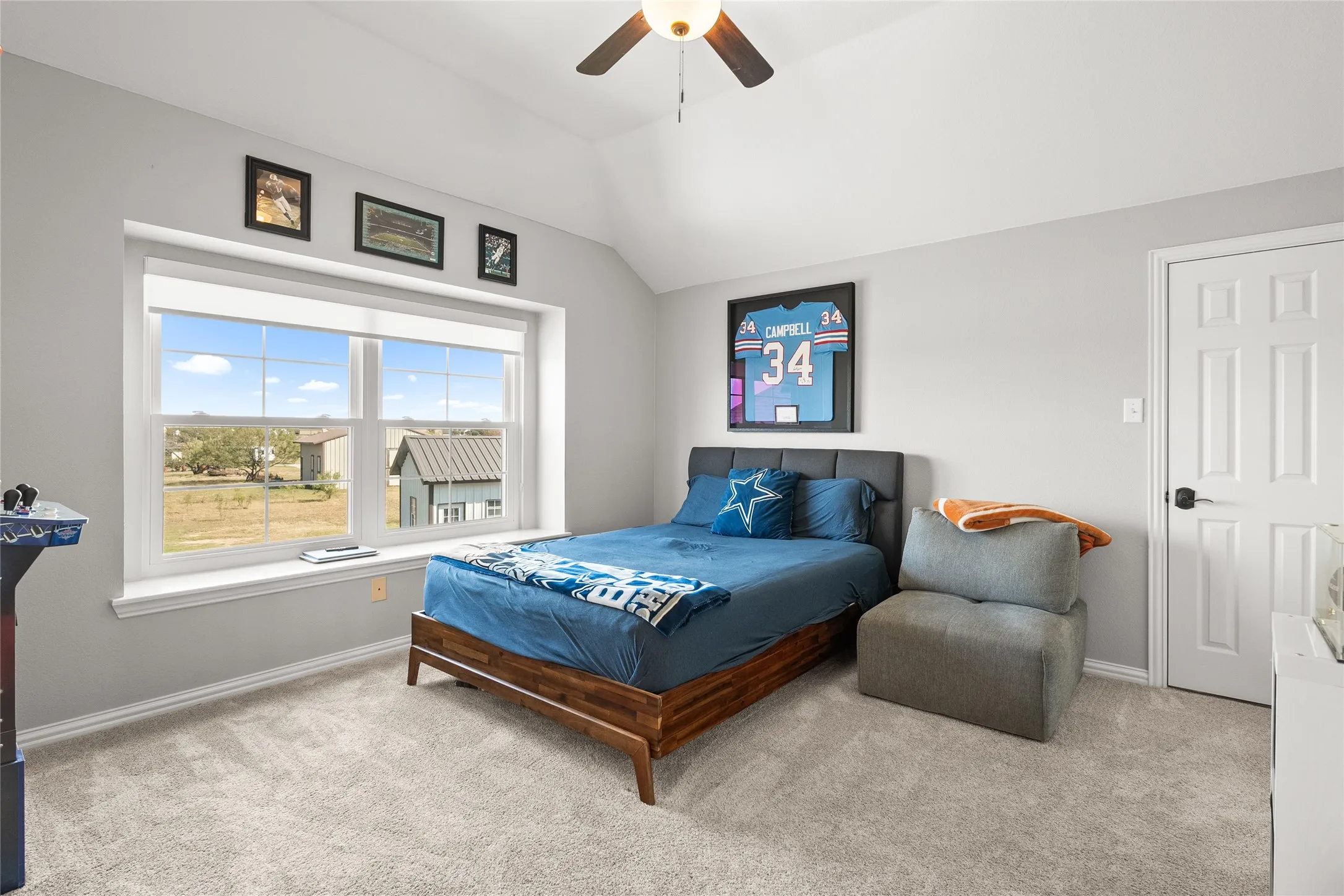 Bedroom featuring light carpet, lofted ceiling, and ceiling fan