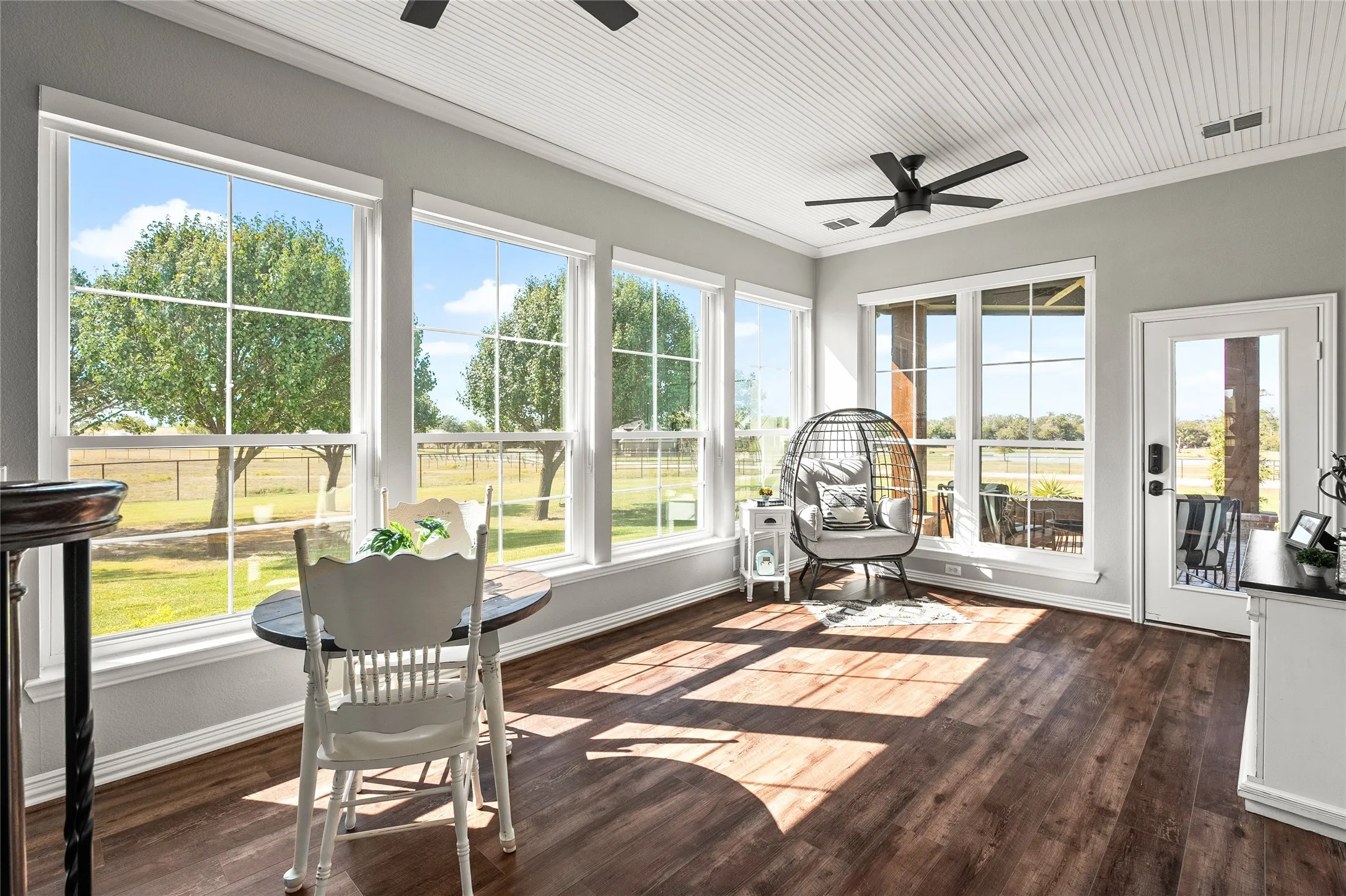 Sunroom / solarium featuring wood finished floors and ornamental molding