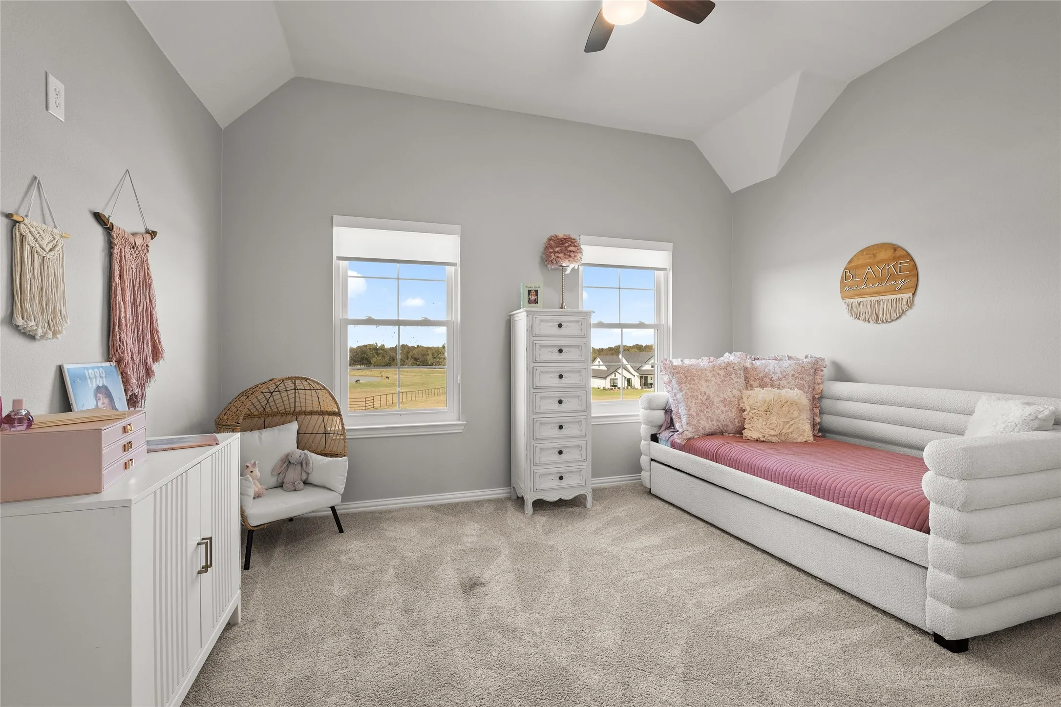 Bedroom with lofted ceiling, light carpet, and ceiling fan