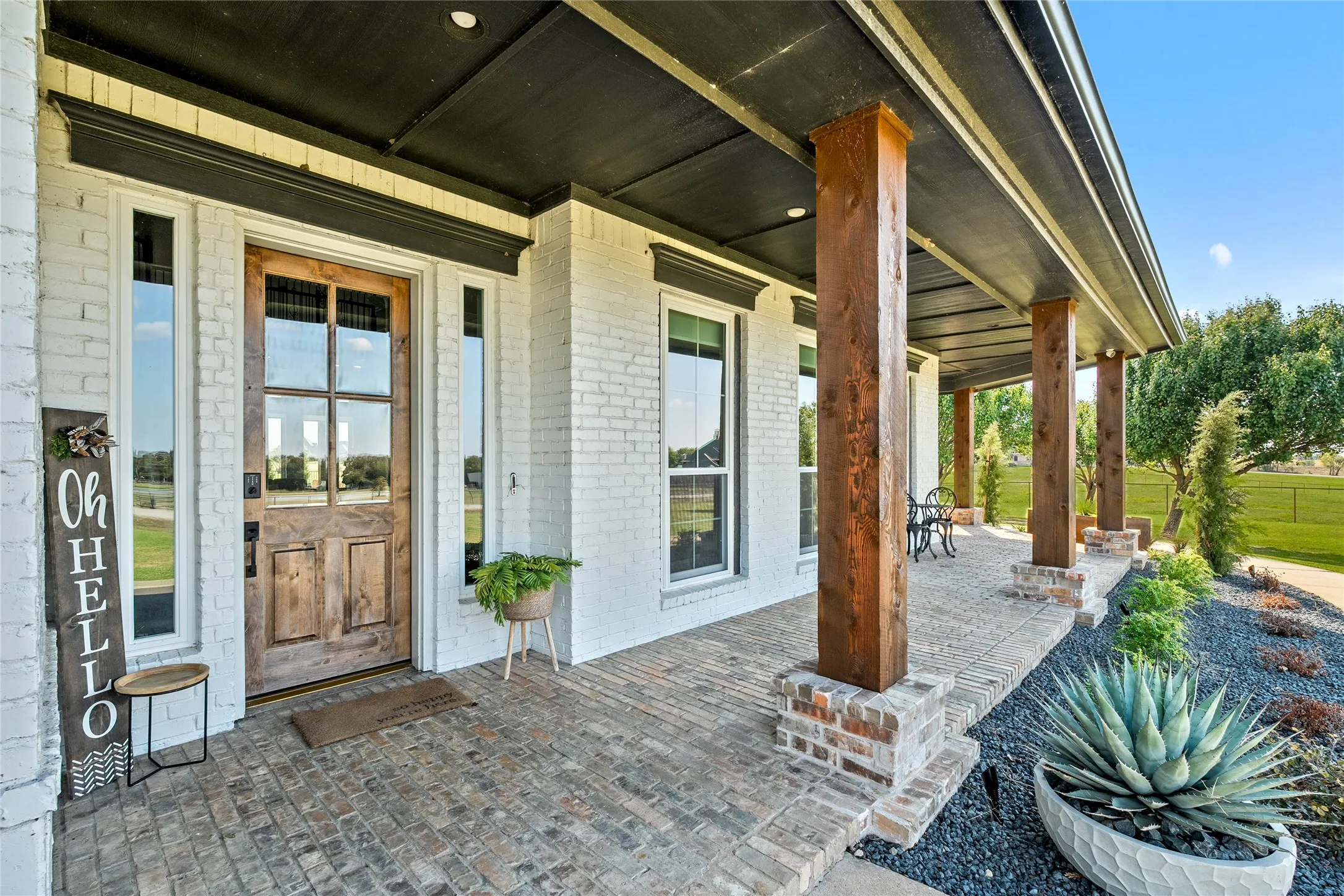 Property entrance featuring a porch and brick siding