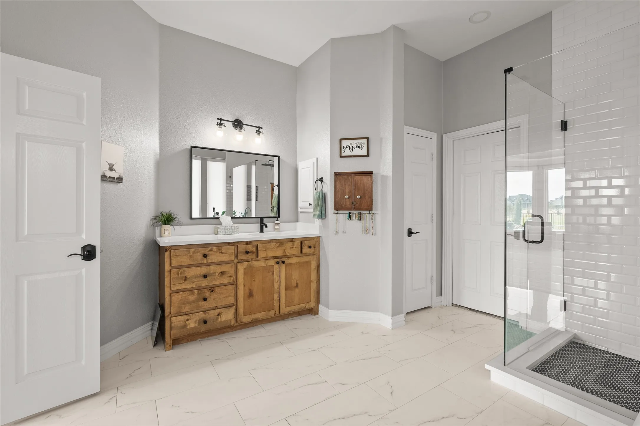 Bathroom with a shower stall, vanity, and light marble finish floors