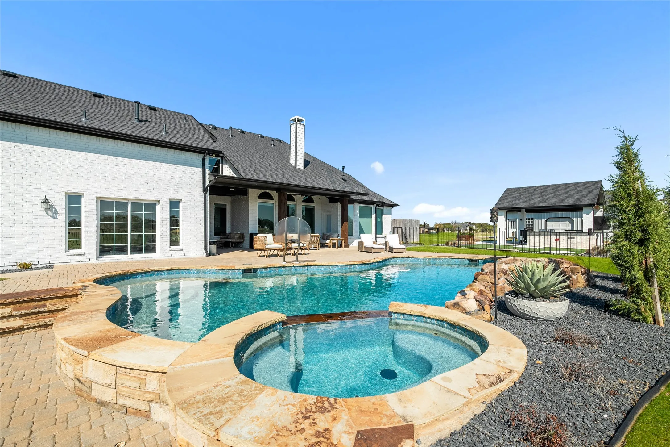 View of pool with a patio area and a pool with connected hot tub