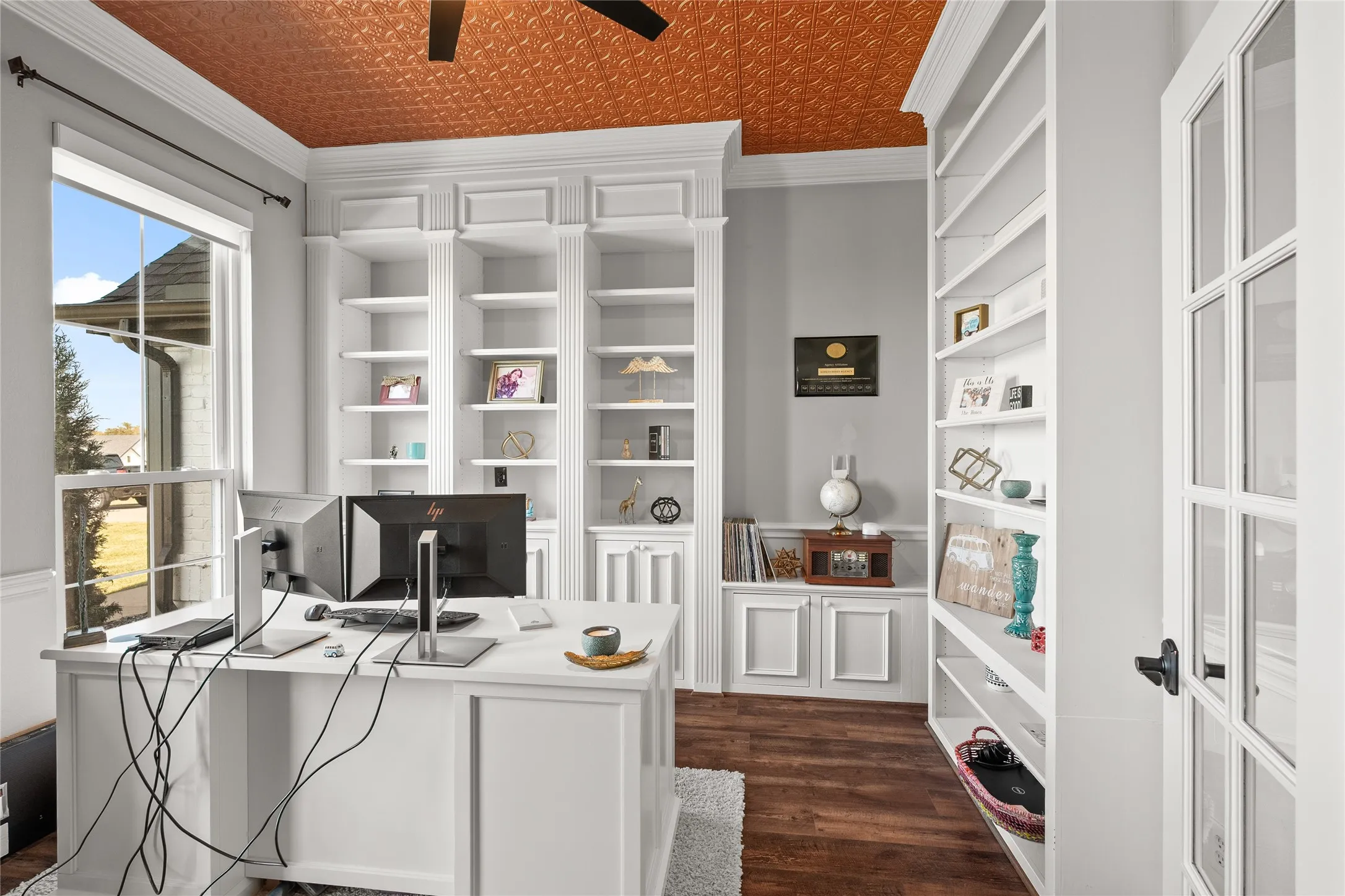 Home office with dark wood-style floors, ceiling fan, and ornamental molding