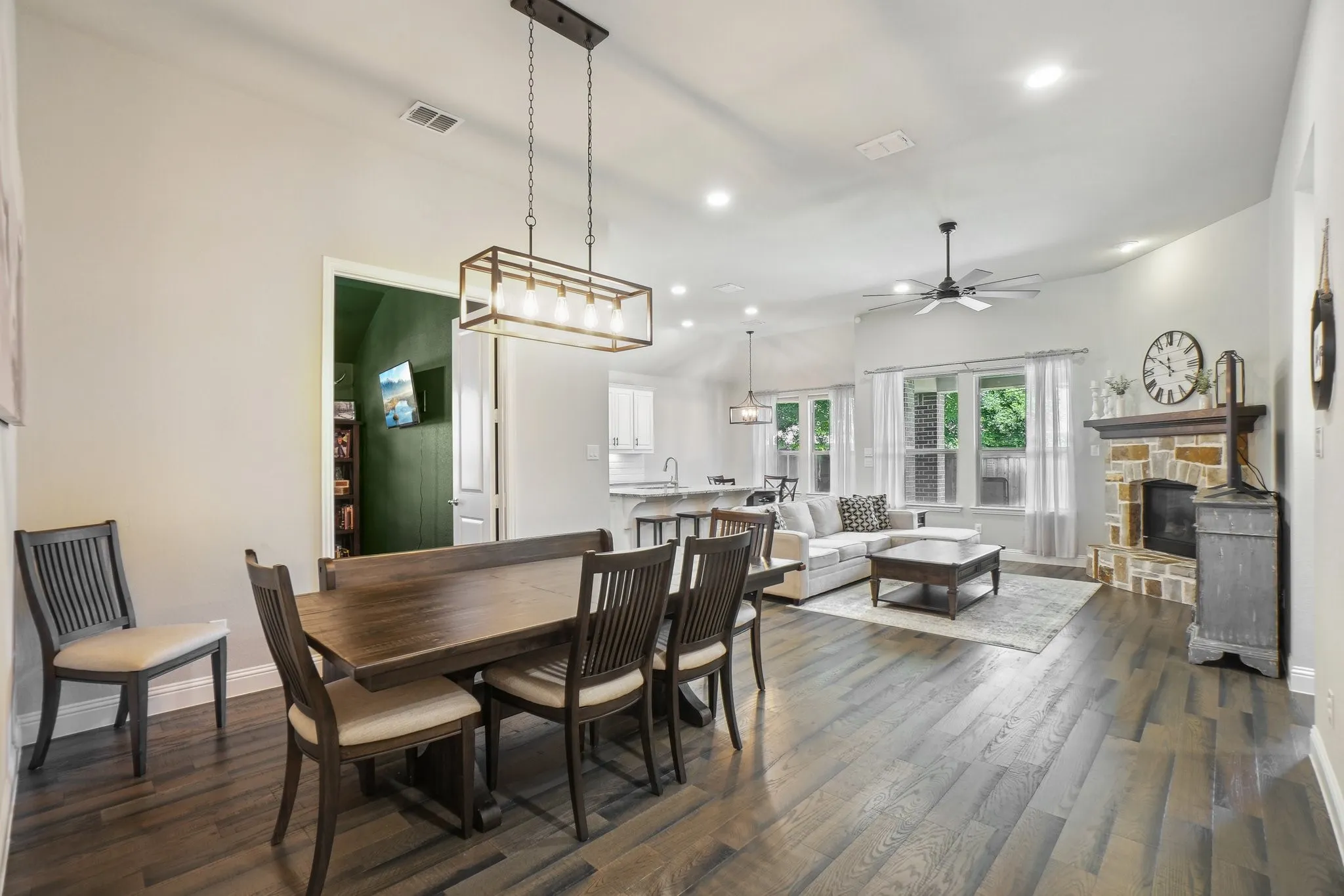 Dining room with dark wood-style floors, recessed lighting, ceiling fan, and a fireplace
