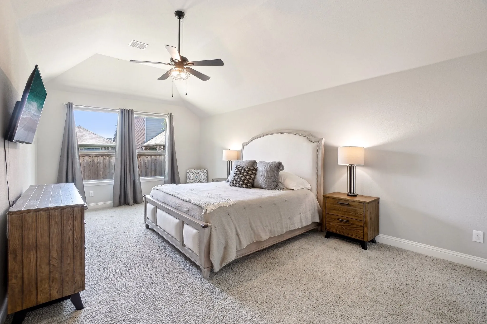 Bedroom featuring light carpet, a ceiling fan, and vaulted ceiling