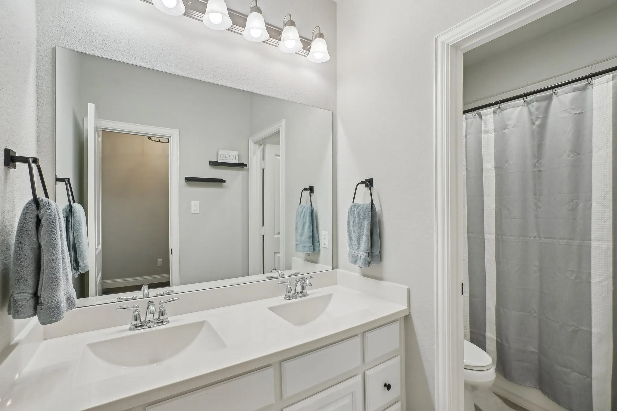 Full bath with double vanity and curtained shower