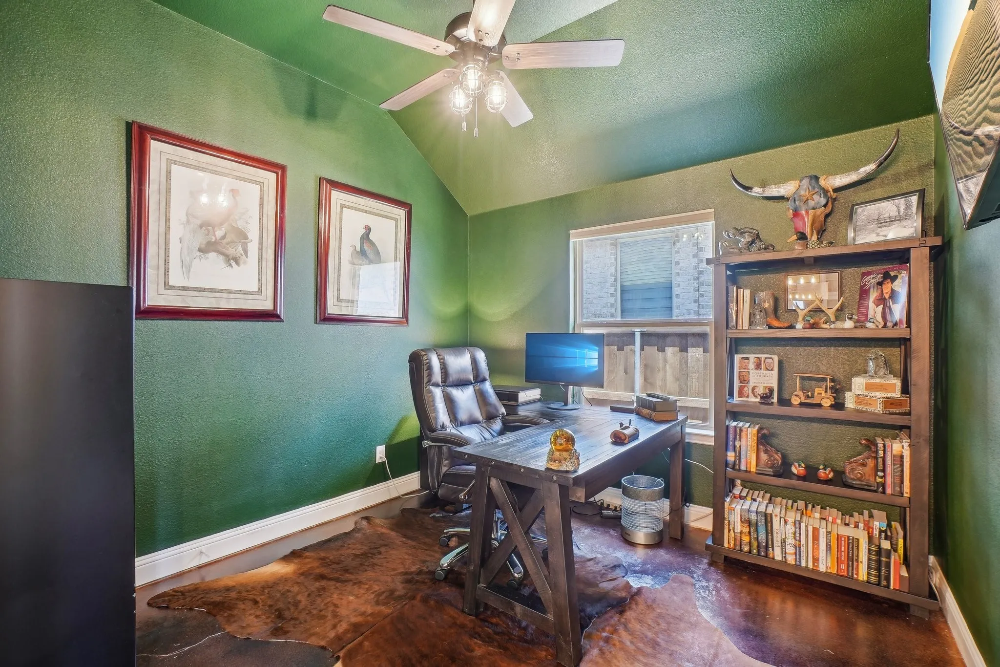 Office space featuring a textured wall, ceiling fan, and lofted ceiling
