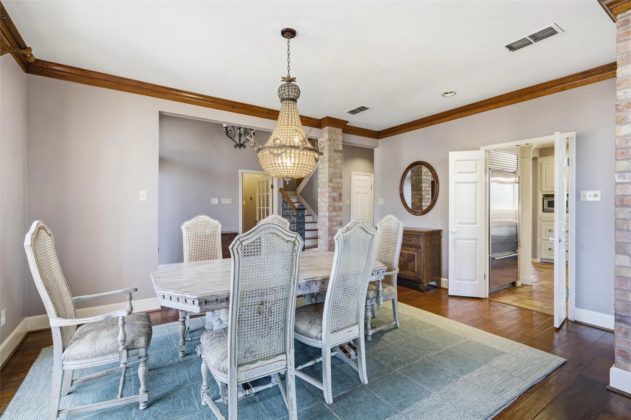Dining area with dark wood finished floors, crown molding, and a chandelier