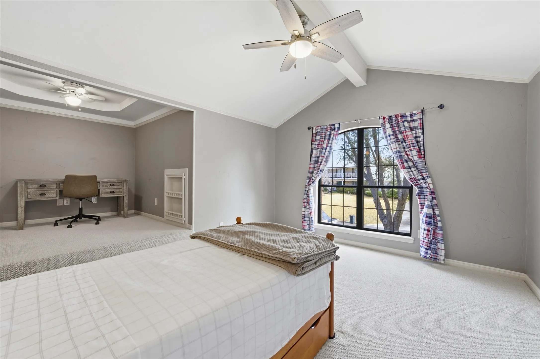 Bedroom featuring carpet floors, beamed ceiling, and a ceiling fan.