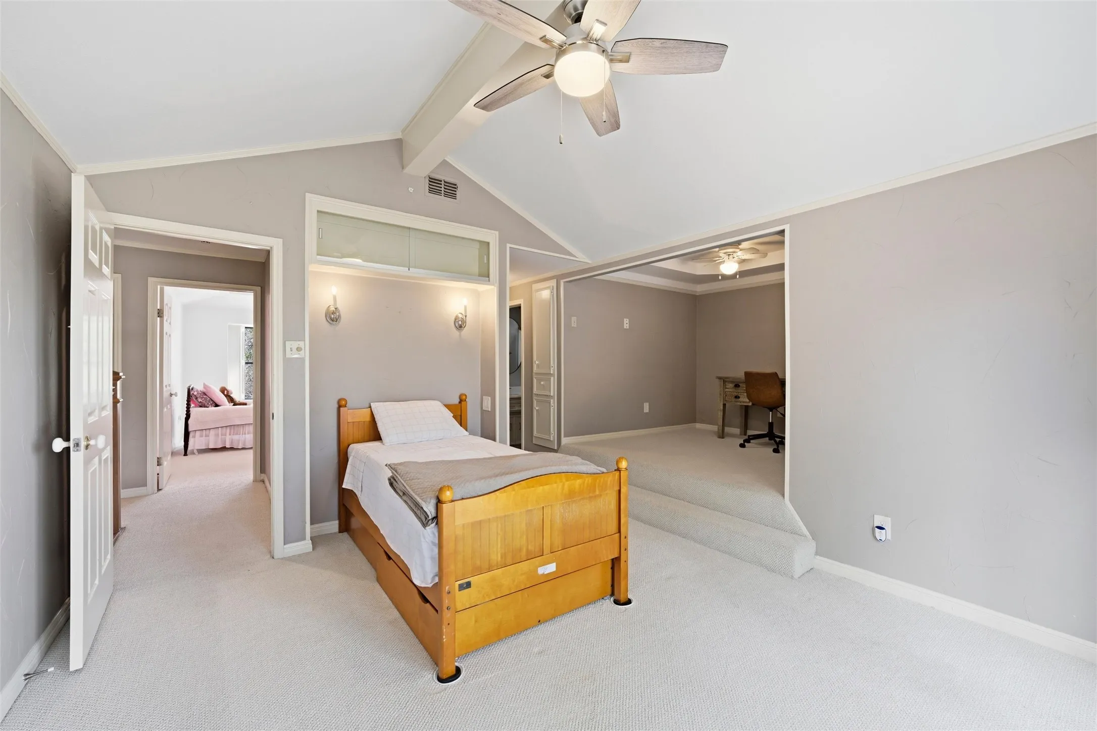 Carpeted bedroom with beam ceiling, a ceiling fan, crown molding, and a desk