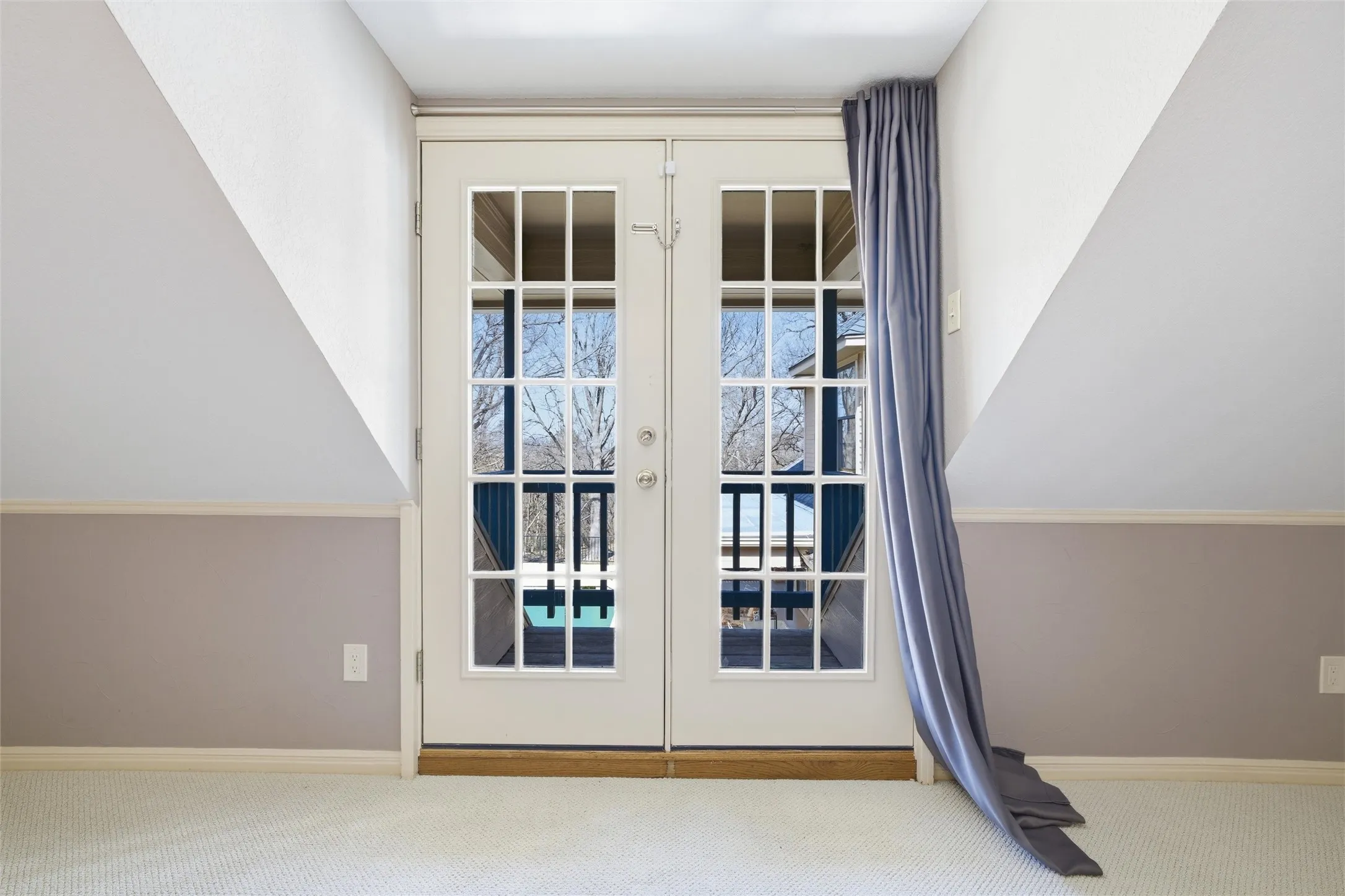 Exit to balcony with french doors and carpet floors