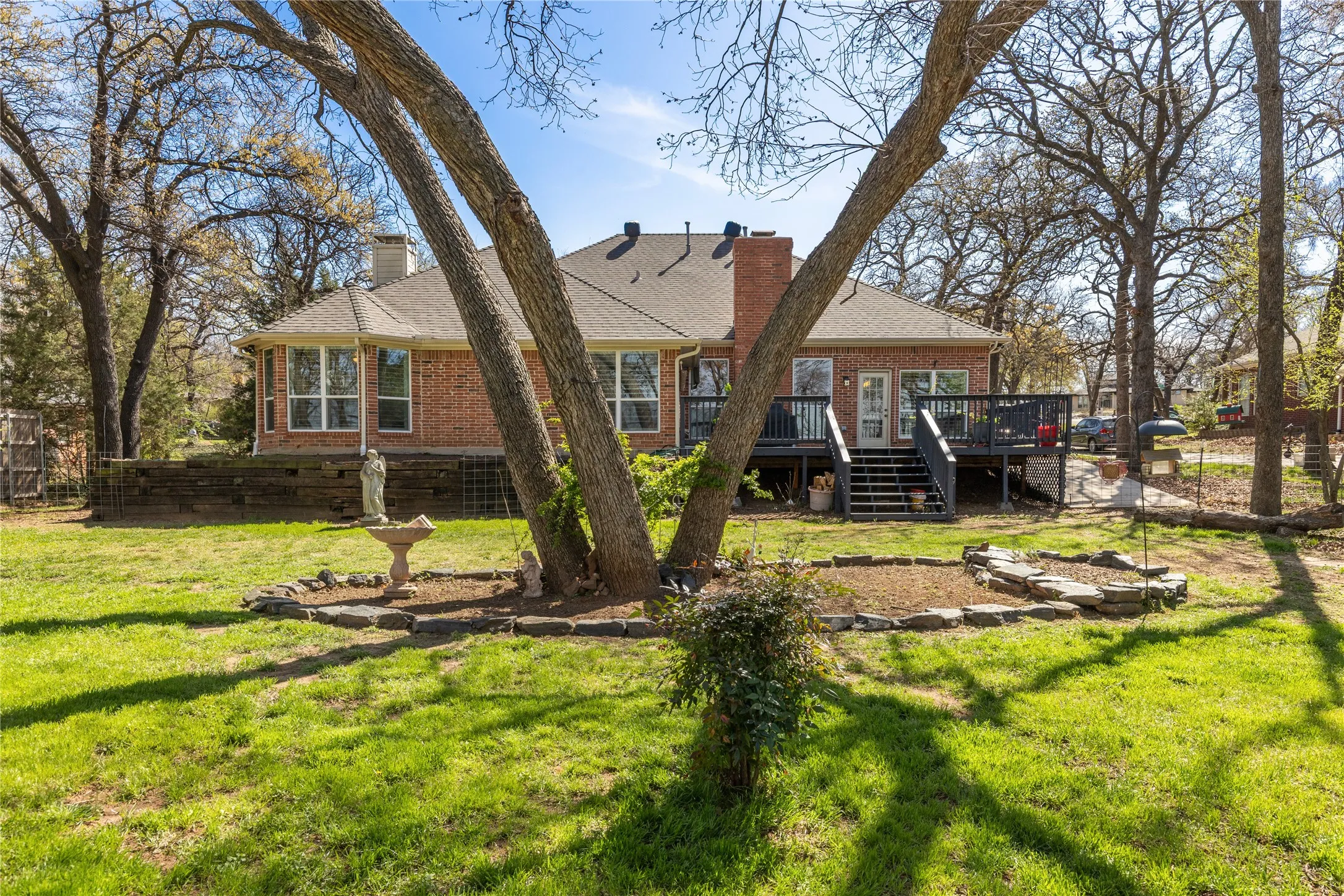 Rear view of property with a chimney, brick siding, and a lawn