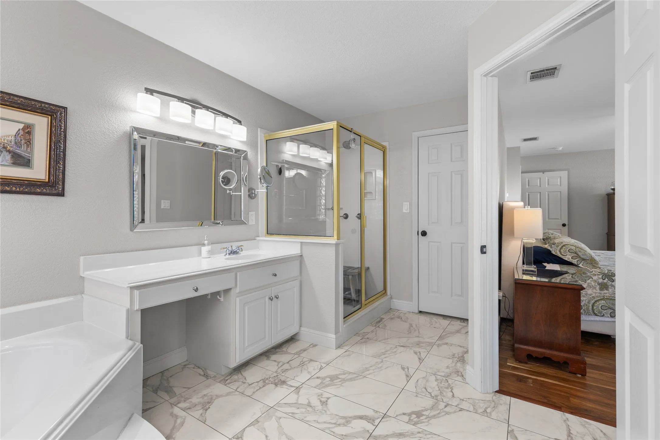 Ensuite bathroom with vanity, a shower stall, light marble finish flooring, and a garden tub