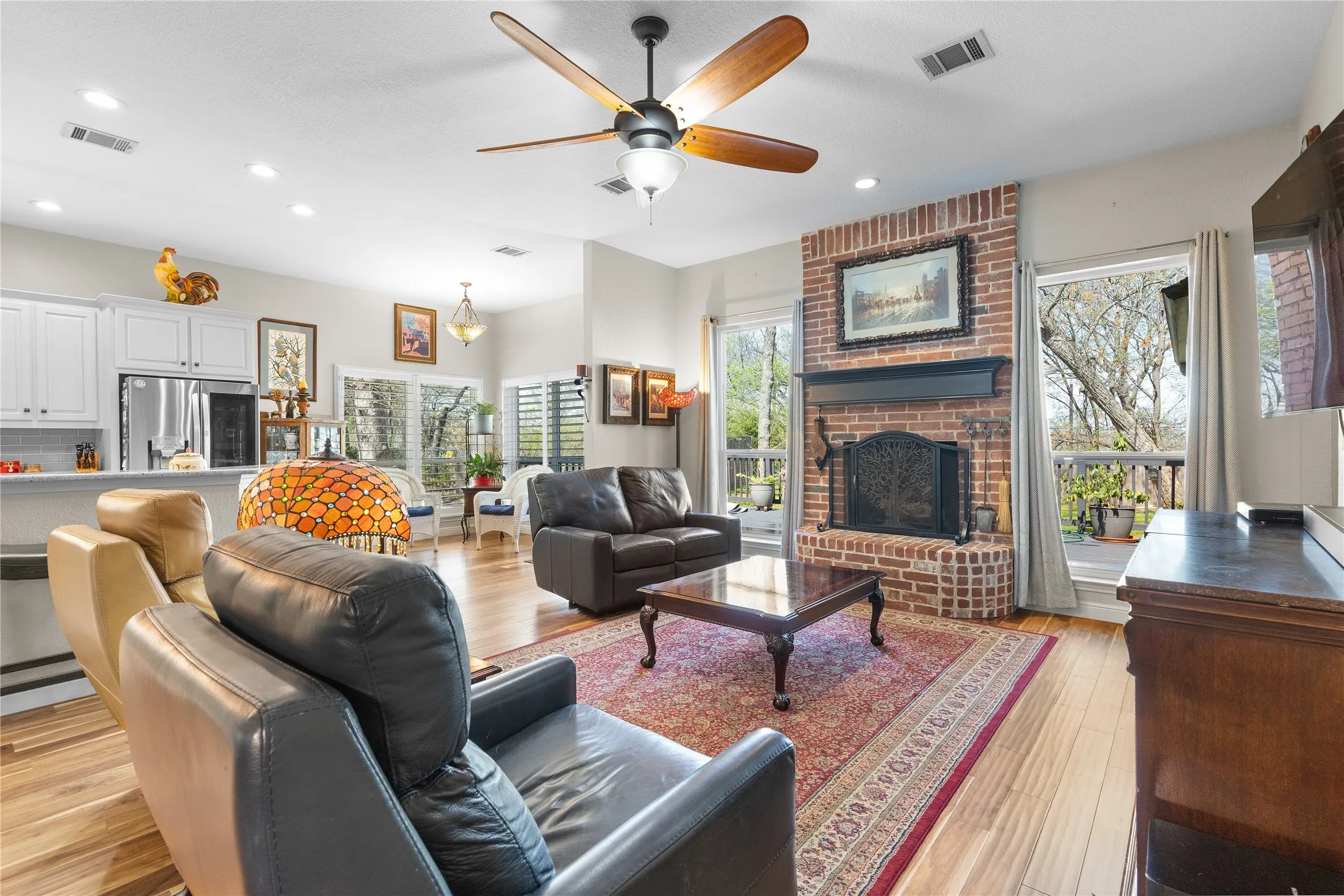 Living room featuring ceiling fan, light wood-type flooring, recessed lighting, and a fireplace
