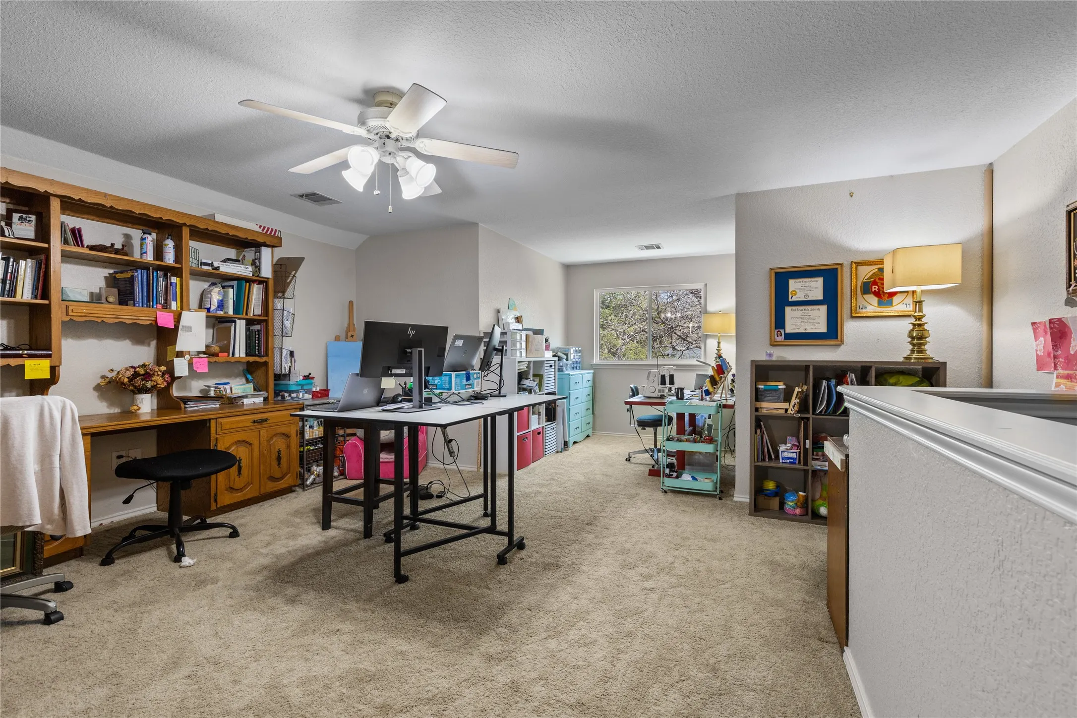 Office space with light colored carpet, a ceiling fan, and a textured ceiling/craft room - this is the only room upstairs