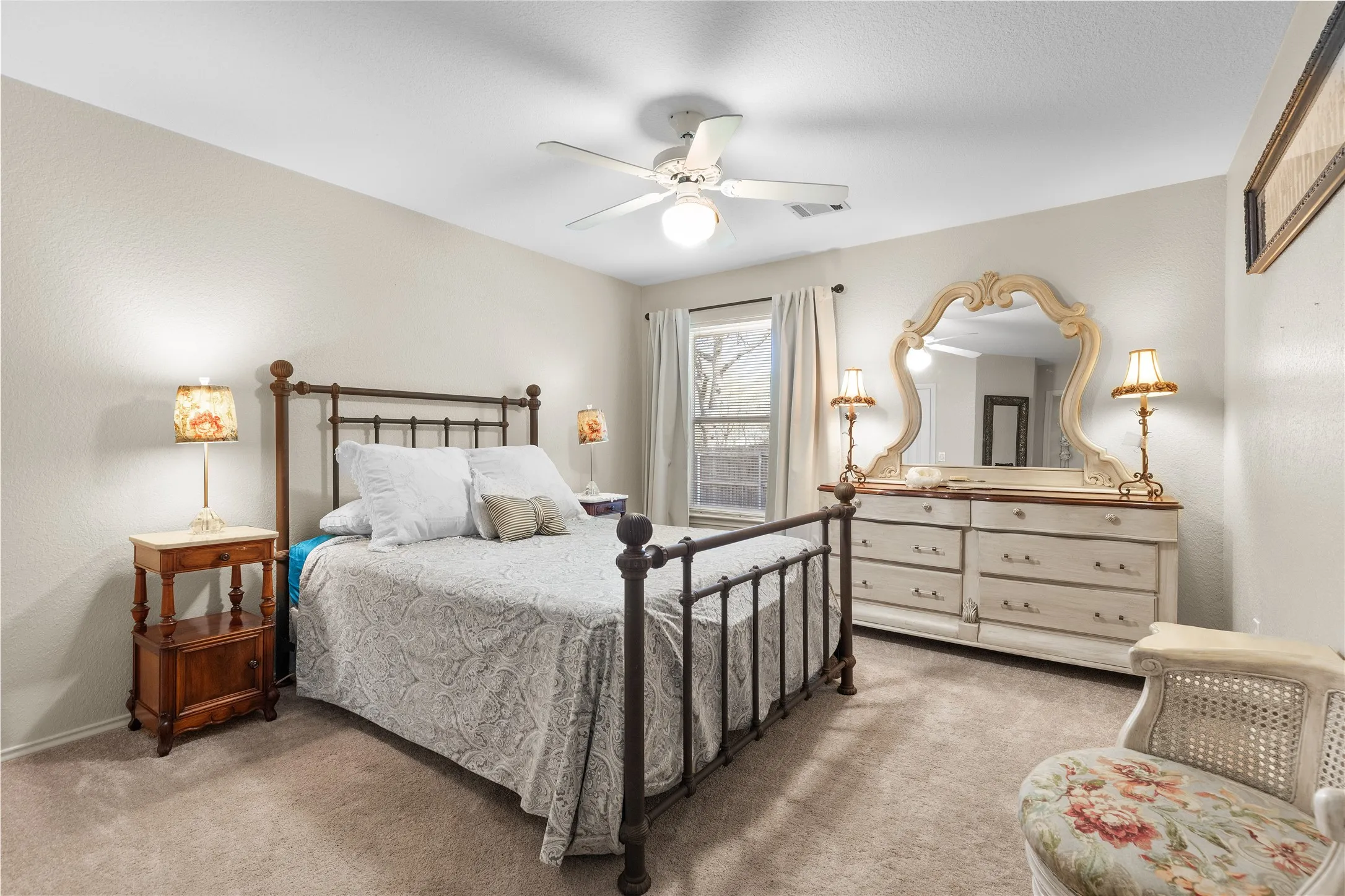Carpeted bedroom featuring ceiling fan and a textured wall