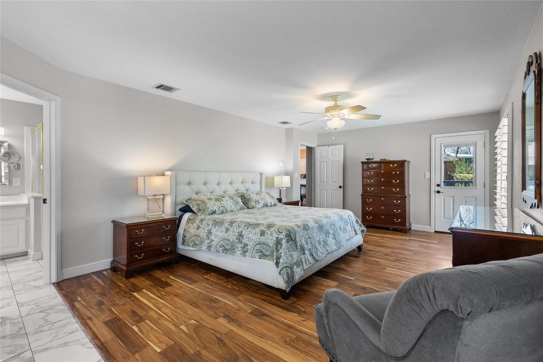 Bedroom featuring dark wood-style flooring, ceiling fan, and ensuite bathroom
